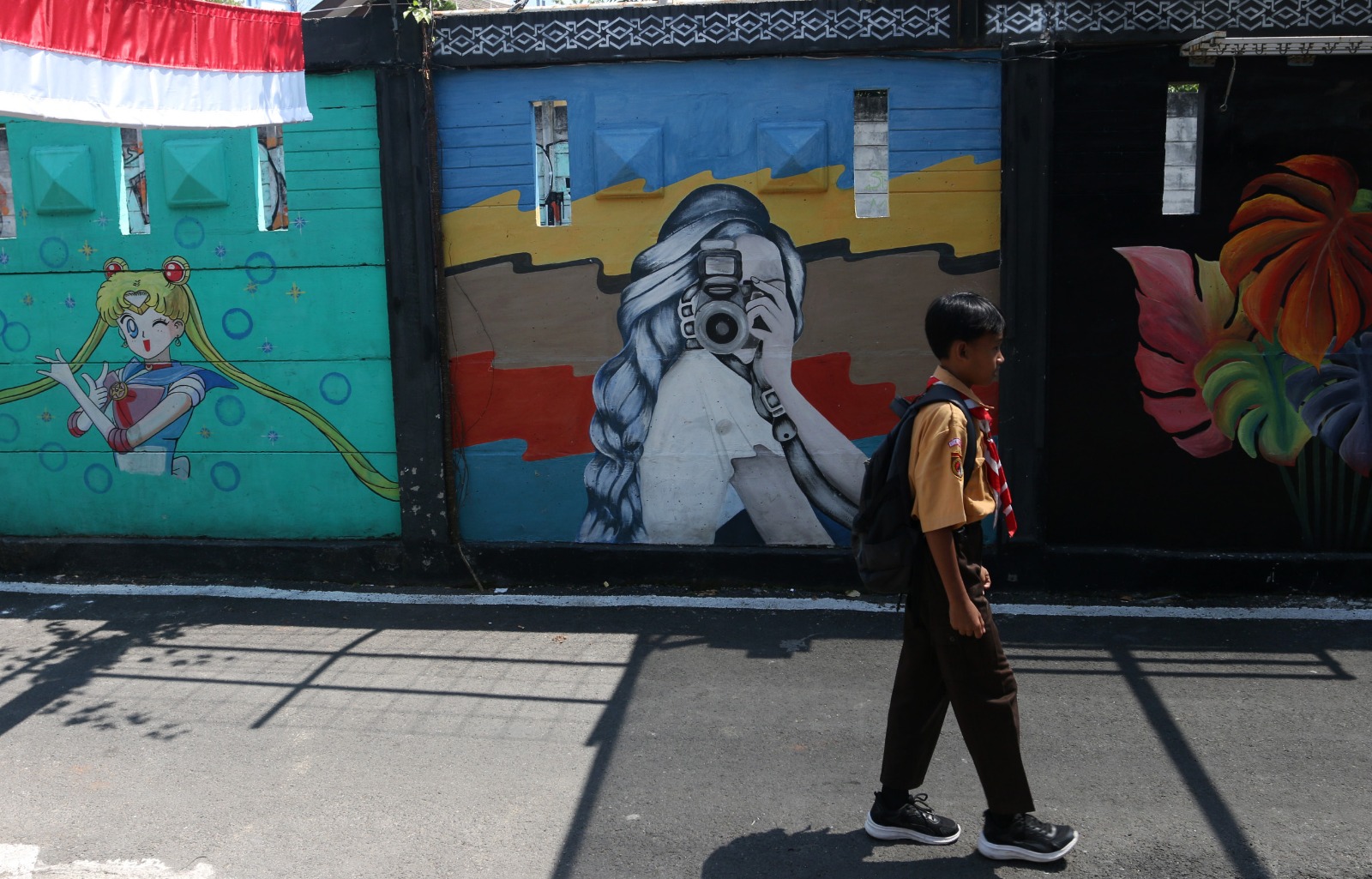 Para warga RT 5 RW 2 Lurah Pendrikan Lor melukis mural tembok pembatas antara rel kereta api dengan pemukiman Jalan Abimanyu V, Rabu (14/8). NUR CHAMIM/JAWA POS RADAR SEMARANG