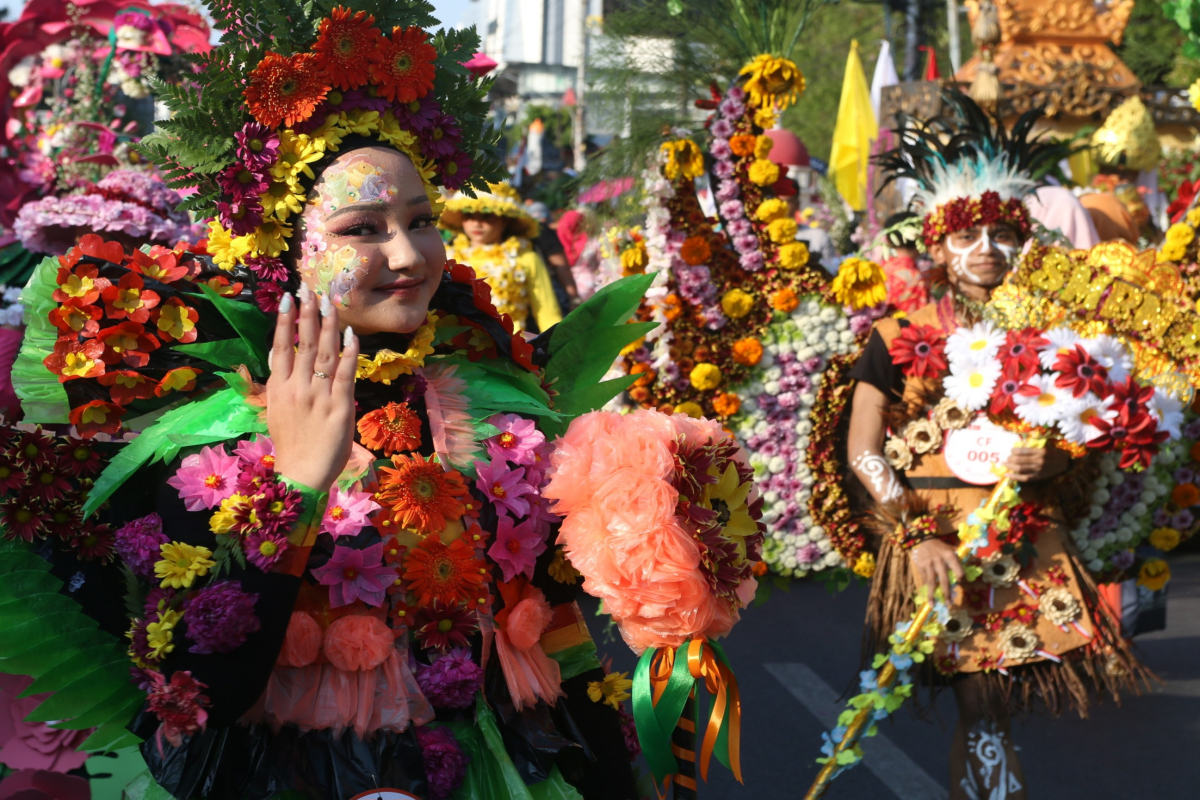 Para peserta Semarang Merdeka Flower tahun 2024 yang menaiki kendaraan hias bertema bunga dari Balaikota Semarang menuju Simpang Lima, Sabtu (24/8). NUR CHAMIM/JAWA POS RADAR SEMARANG