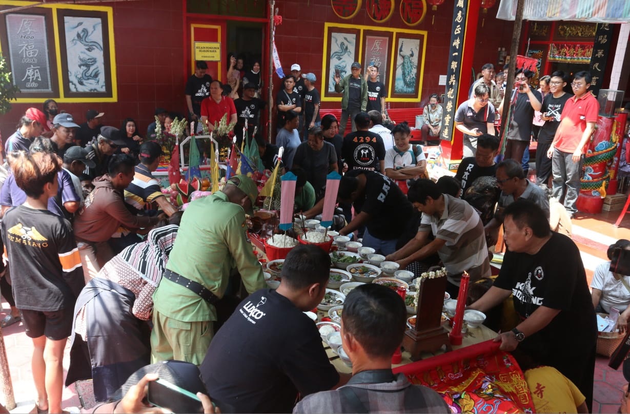 Warga berebut alat sekolah dan alat rumah tangga di bawah meja sesaji setelah Sembahyang Ulambana di Kelenteng Hoo Hok Bio, Jumat (23/8).