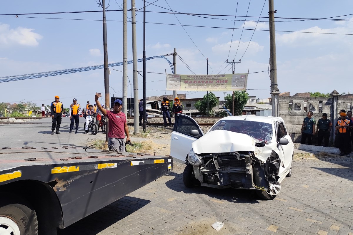 Sebuah mobil berpenumpang lima orang tertabrak kereta api di perlintasan double track tanpa palang pintu. (M Hariyanto/Jawa Pos Radar Semarang)