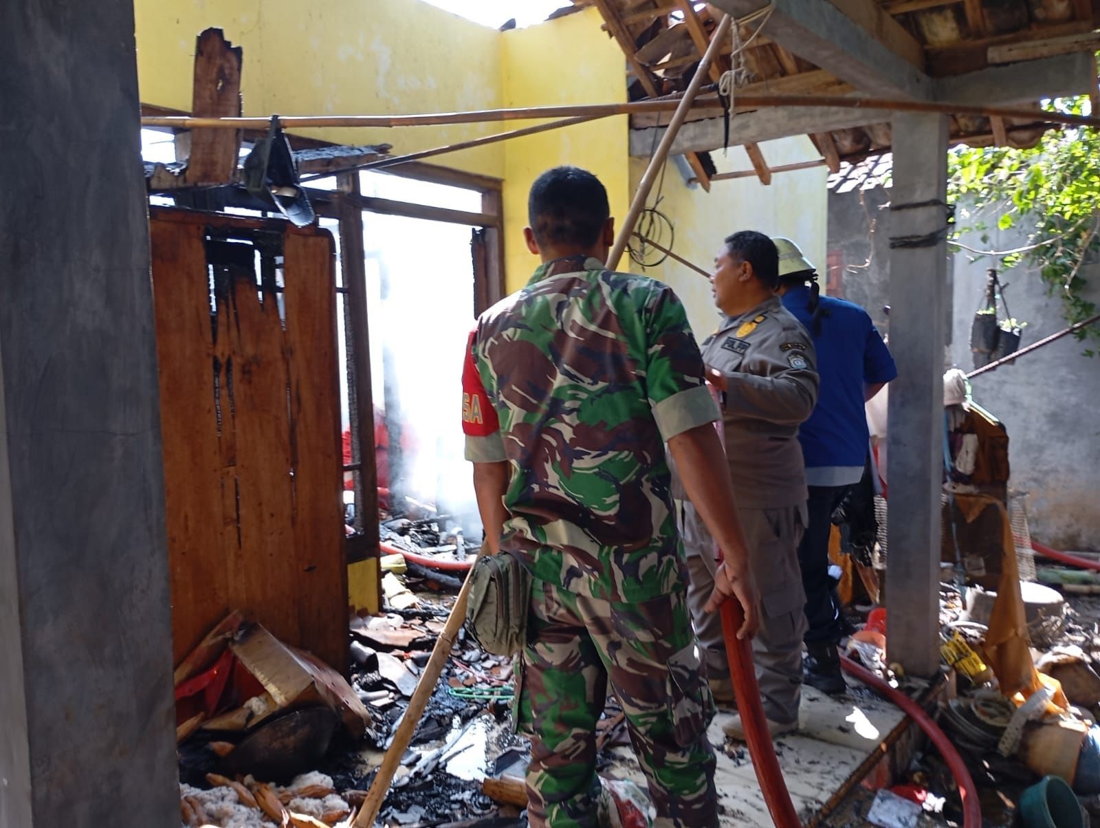 Petugas damkar berupaya memadamkan api yang membakar rumah Rukayah di Desa Sambongsari, Kecamatan Weleri, Rabu (18/9) pagi.
