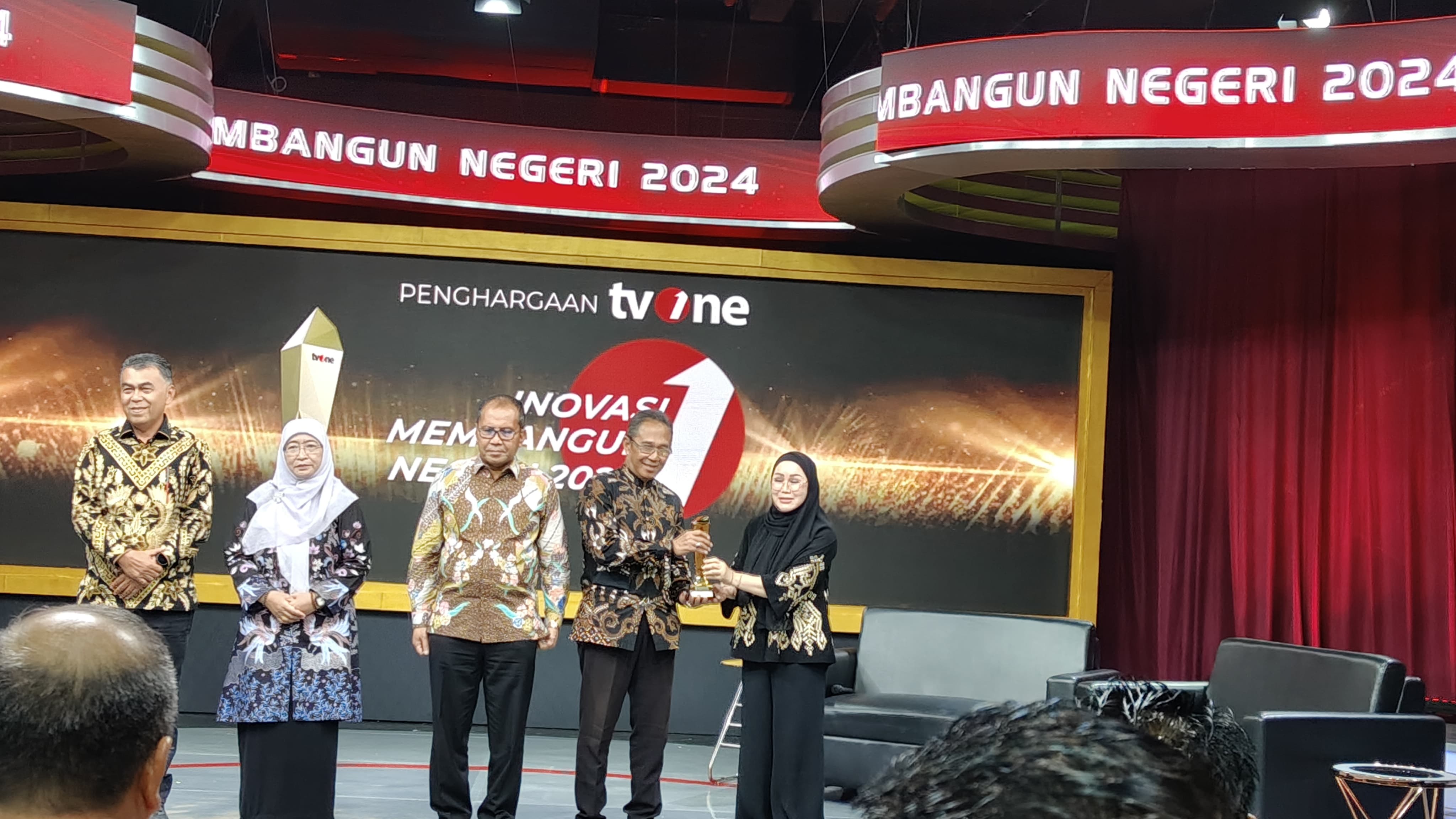 Maria Goretti Limi, Direktur Sales dan Marketing TV One menyerahkan penghargaan kategori sektor ketahanan pangan untuk penanganan stunting kepada wali kota Semarang yang diwakili Kabag Kompimpro.