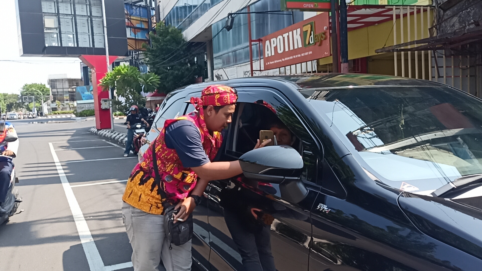 Juru parkir di Jalan Thamrin, ketika menerima pembayaran non tunai dari pengguna jalan. (Adennyar Wycaksono/Jawa Pos Radar Semarang)