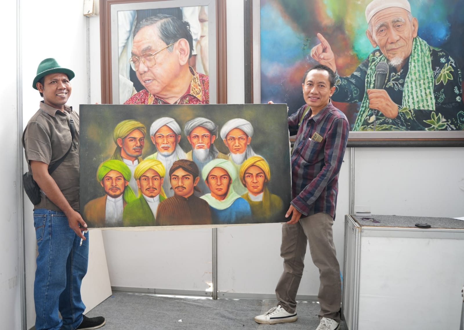 Pelukis Mukhlison Jalembung menunjukkan lukisan Walisongo dalam pameran Demak Expo. (Wahibpribadi)