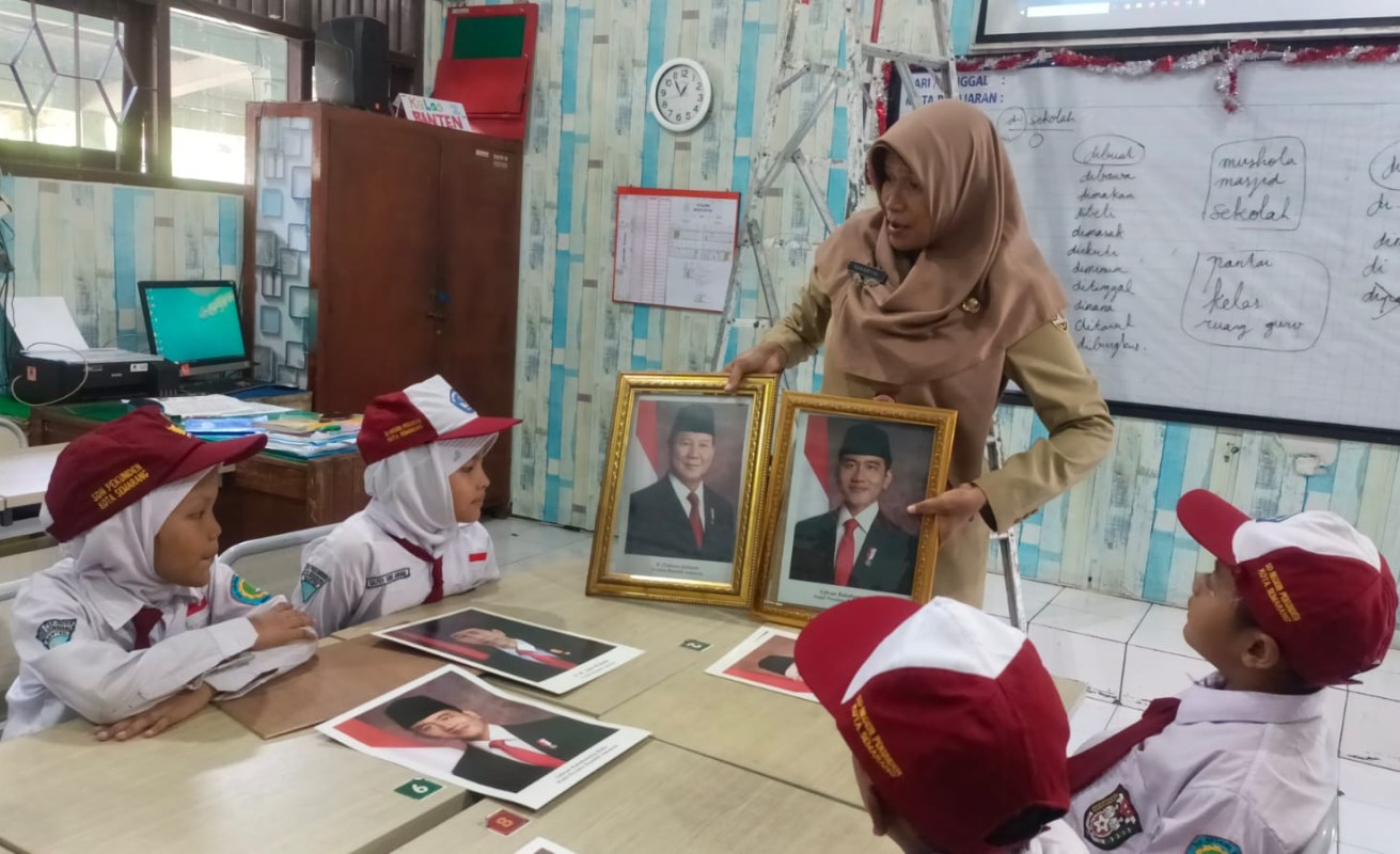 Para siswa dan guru SD Negeri Pekunden&nbsp;memasang foto presiden kedelapan Prabowo Subianto - Gibran Rakabuming Raka, Senin (21/10). NUR CHAMIM/JAWA POS RADAR SEMARANG