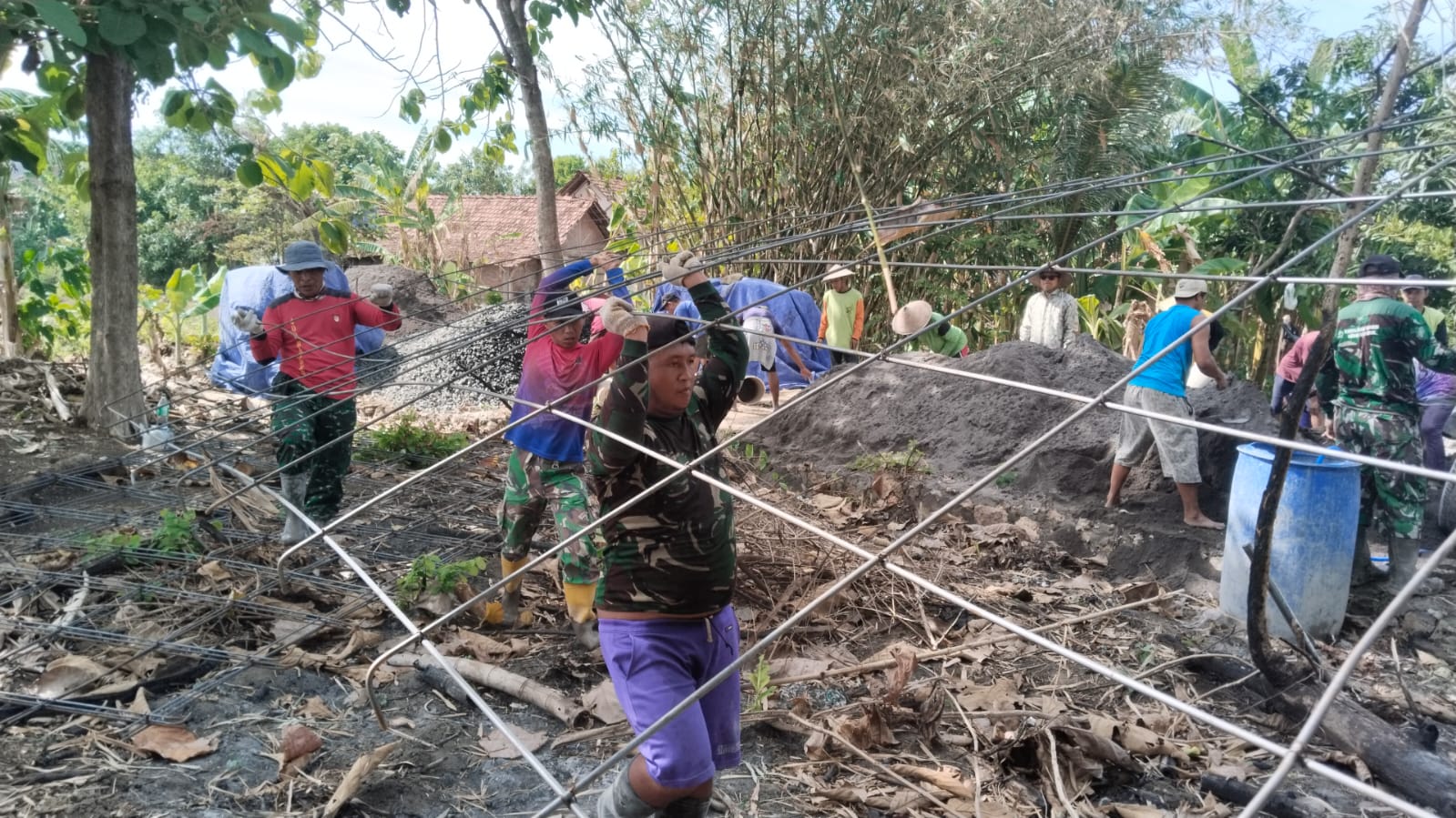 Aparat TNI bersama warga bahu membahu menyelesaikan jalan di Desa Karangrejo Kecamatan Dempet. (Wahibpribadi)