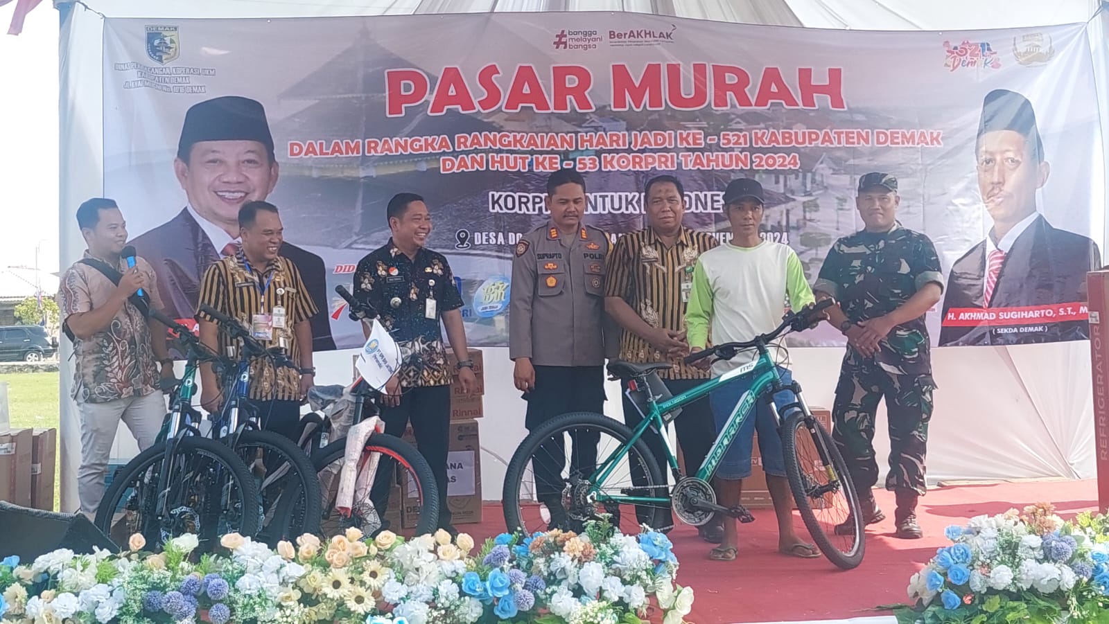 Kepala Dindagkop UKM Iskandar Zulkarnain menyerahkan hadiah undian dalam pasar murah. (Wahibpribadi)