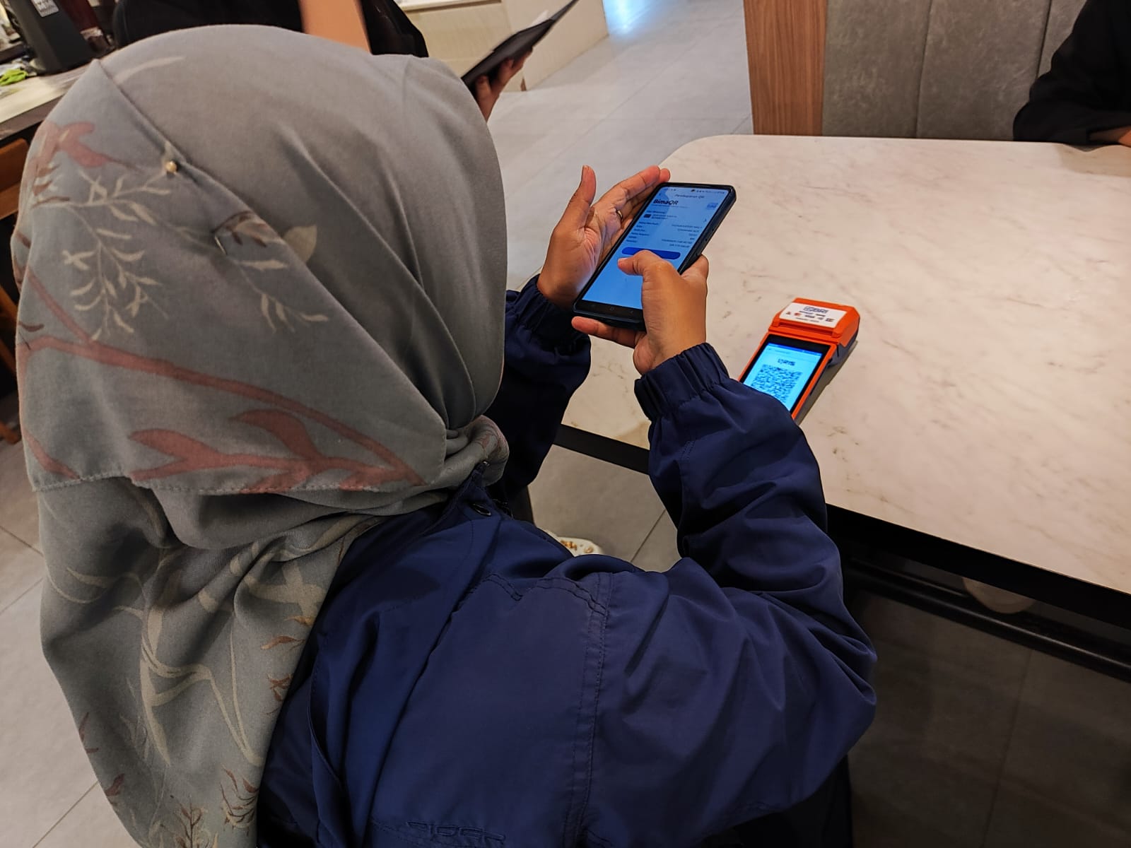 Salah satu pembeli melakukan transaksi pembyaran menggunakan QRIS.