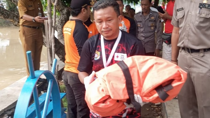 Petugas mengevakuasi jasad bayi laki laki dari pintu air Desa Sedayu, Senin (9/12/2024).