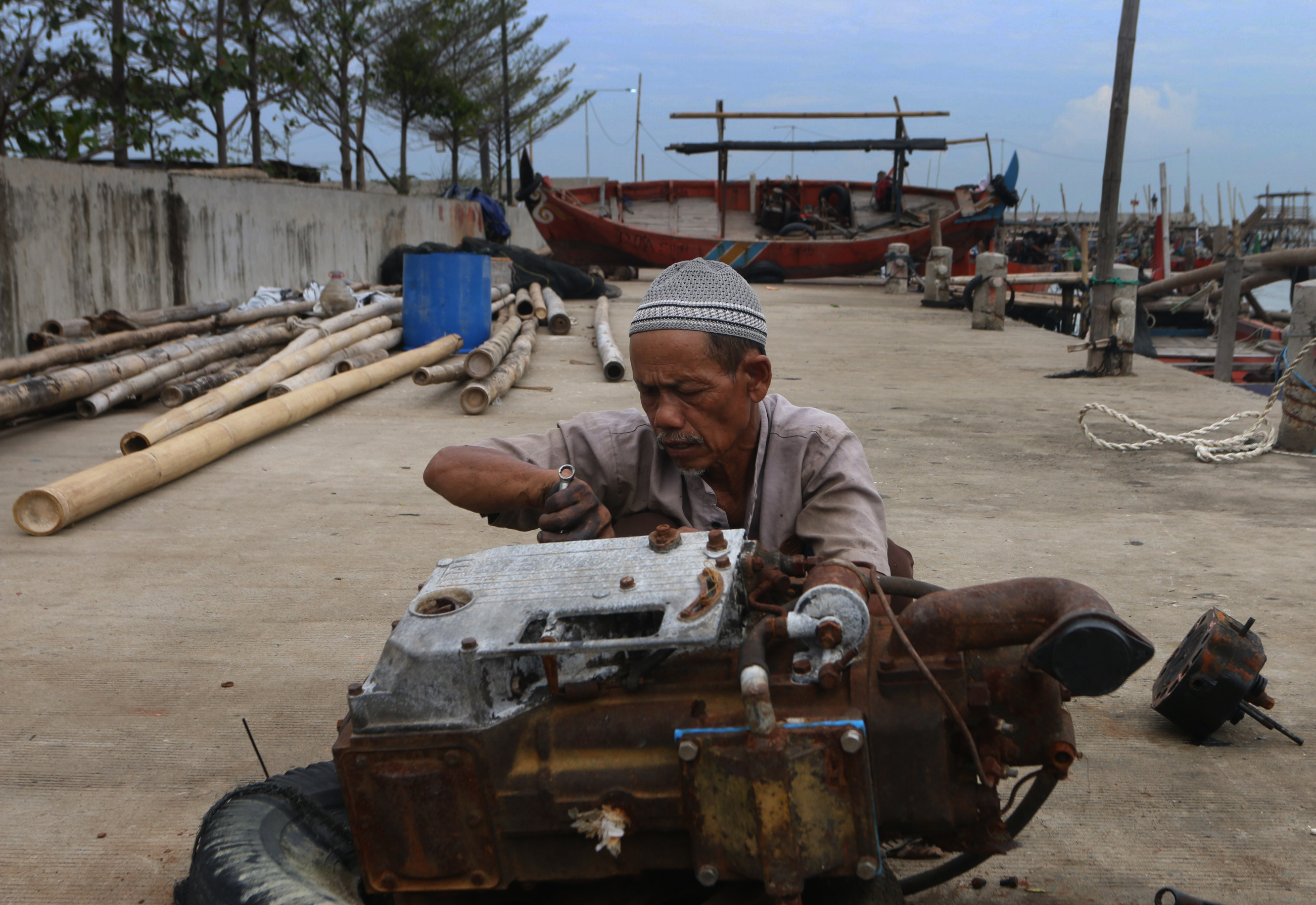 Nelayan Tambaklorok Semarang memperbaiki perahu dan mesin