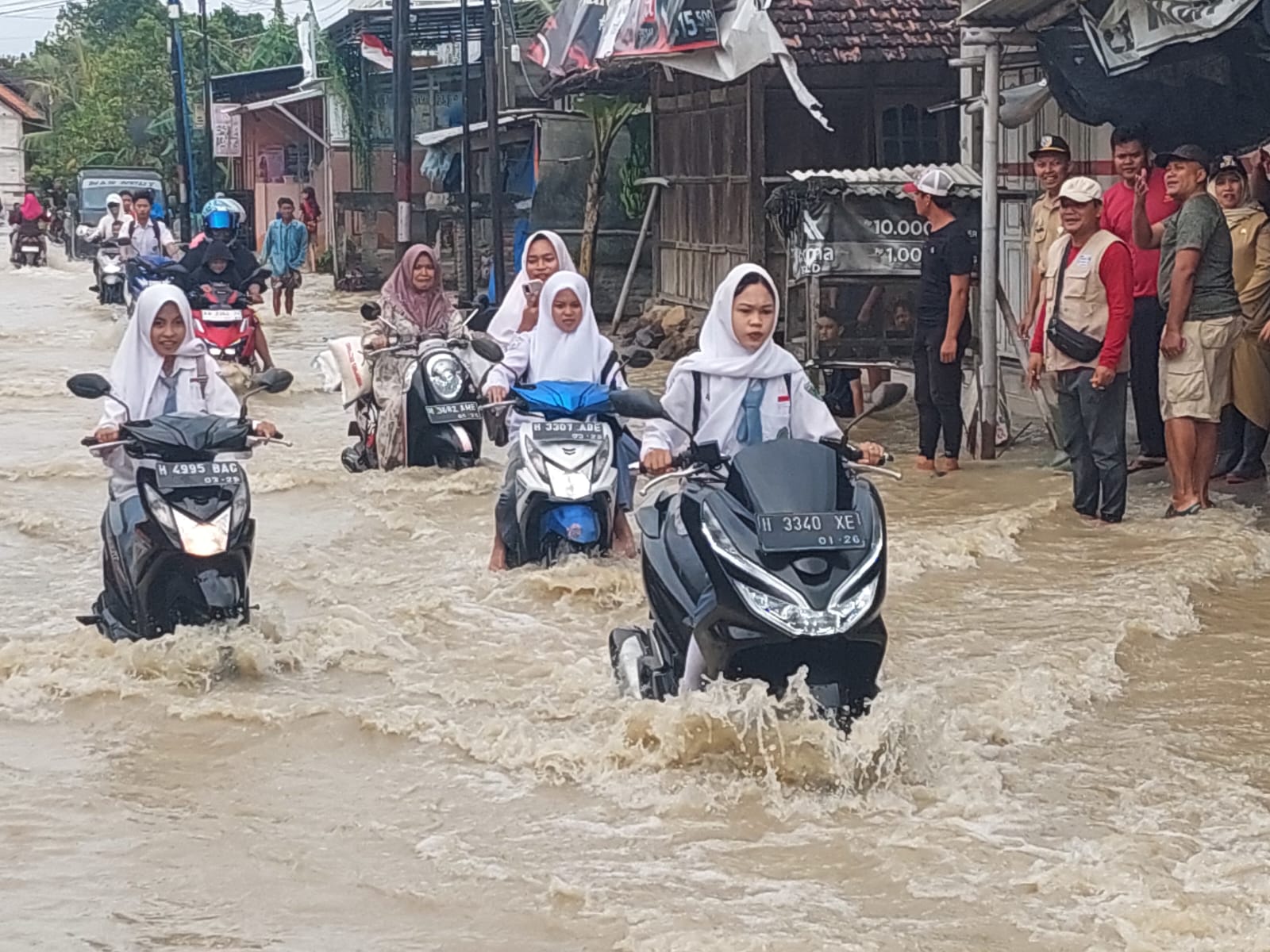 Anak-anak sekolah nekat menerjang banjir di jalan Desa Ploso Karangtengah.(Wahibpribadi)