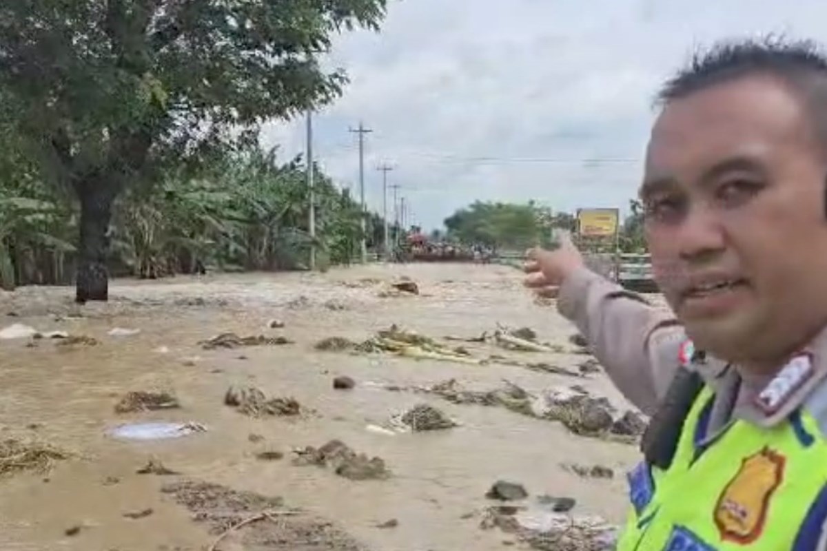 Personel kepolisian berada di lokasi yang terdapat titik tanggul jebol&nbsp;