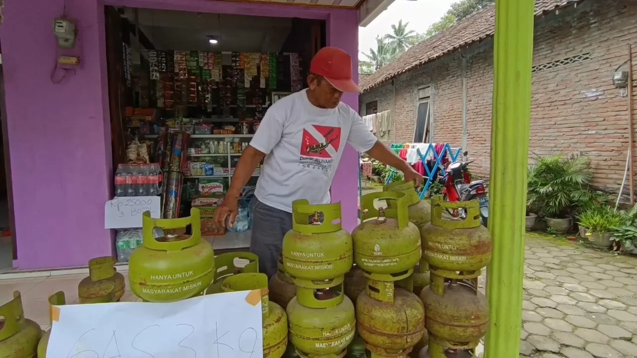Warga Desa Plumbon tengah mencari gas elpiji tiga kilogram di warung terdekat