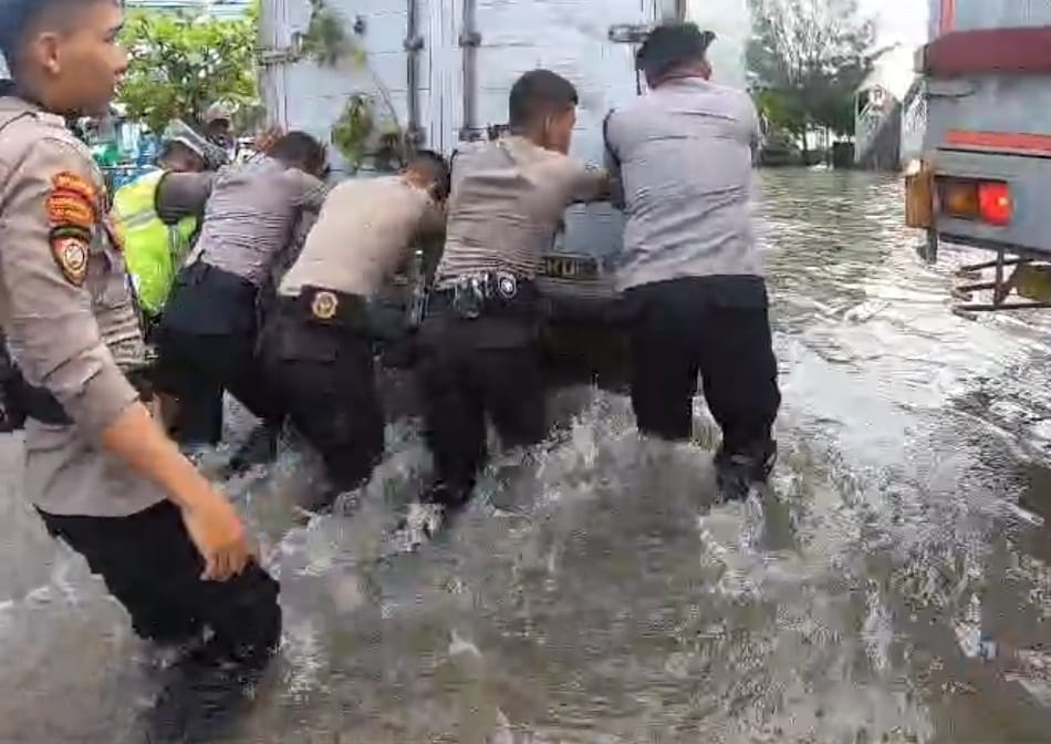 Polda Jateng bersama Polrestabes Semarang mengerahkan personil hingga truk Dalmas untuk membantu dan memberikan pertolongan dampak banjir di Jalan Kaligawe Raya, Kecamatan Genuk Jumat (7/2/2025).