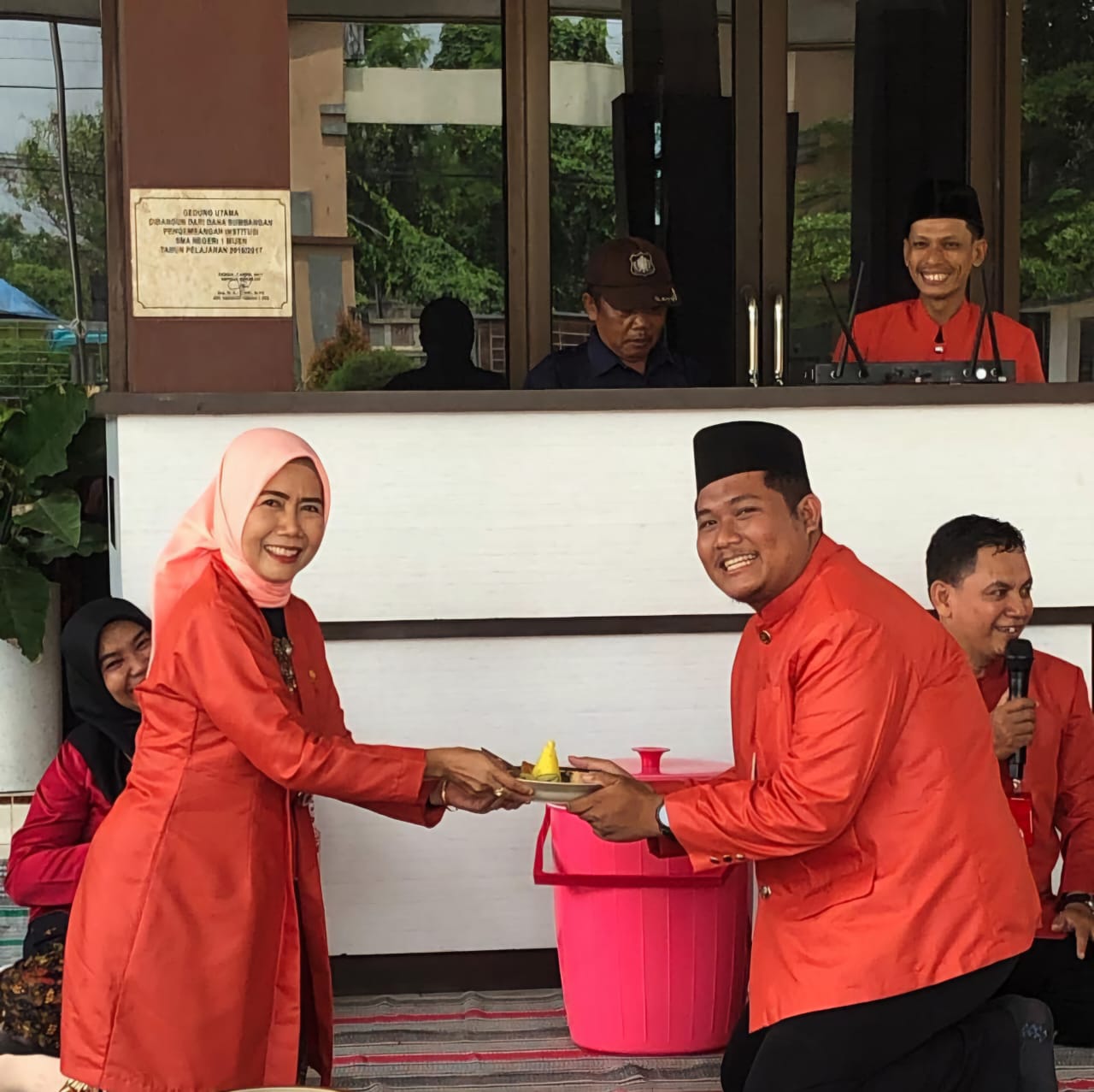 Kepala SMAN 1 Mijen Mustaqimah, SPd, MPd menyerahkan potongan tumpeng kepada guru sekolah.(Wahibpribadi)