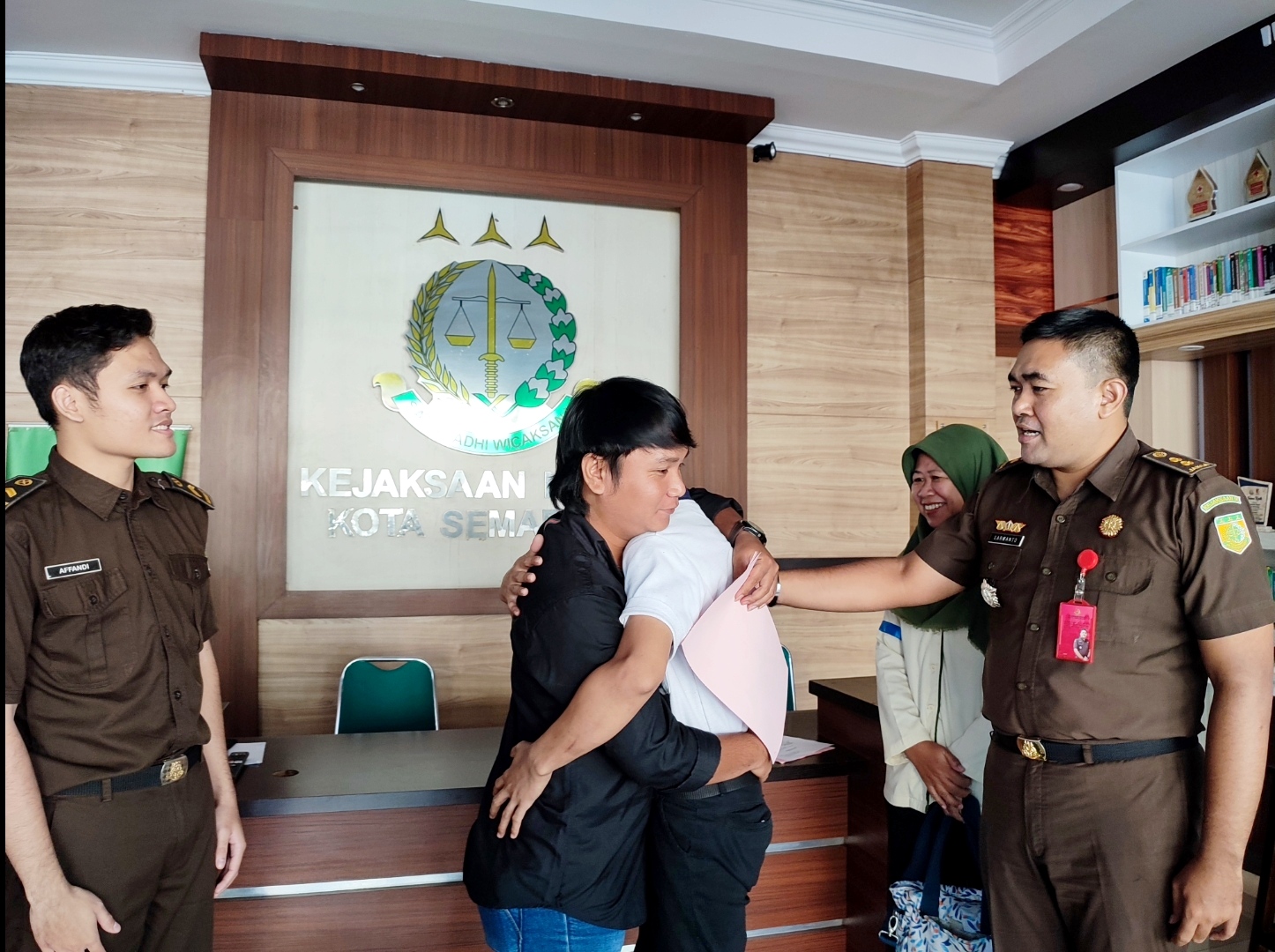 Tersangka Debi (baju hitam) dan korban Fadhil (baju putih) saat berpelukan usai berdamai disaksikan Kepala Seksi Tindak Pidana Umum Kejaksaan Negeri Kota Semarang, Sarwanto, Selasa (4/3/2025).
