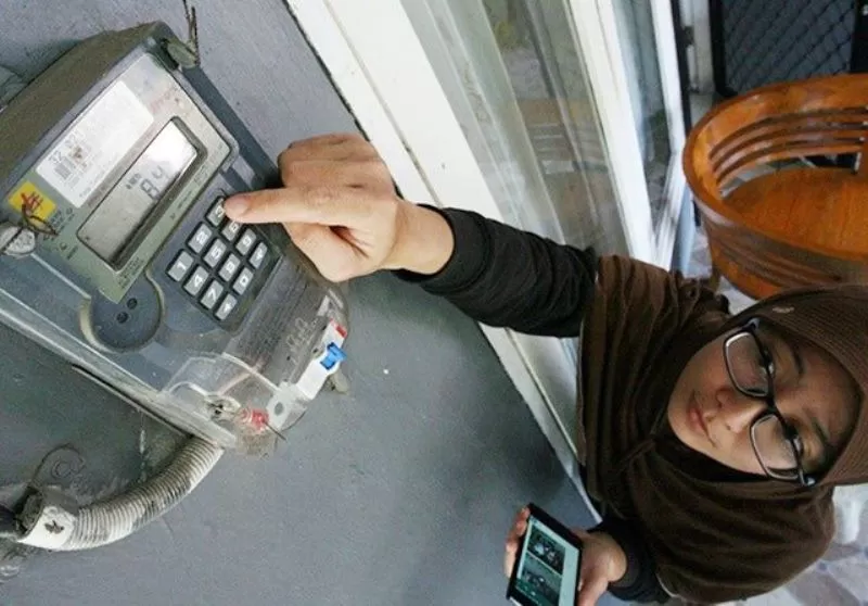 Seorang pelanggan mengisikan token listrik untuk mendapatkan diskon 50 persen.