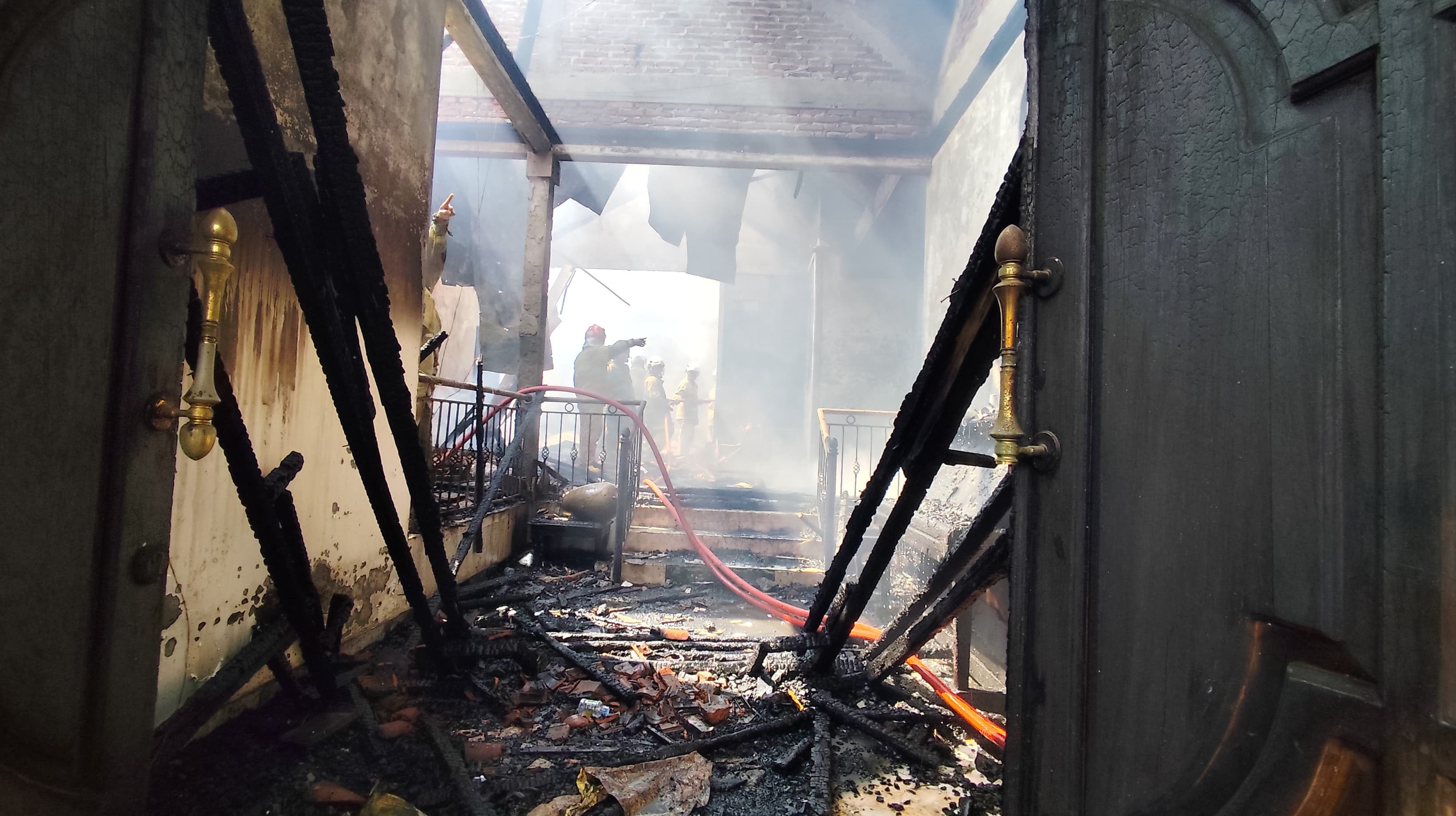 FOTO Mobil di dalam garasi hangus terbakar dan petugas pemadaman masih melakukan pemadaman api.