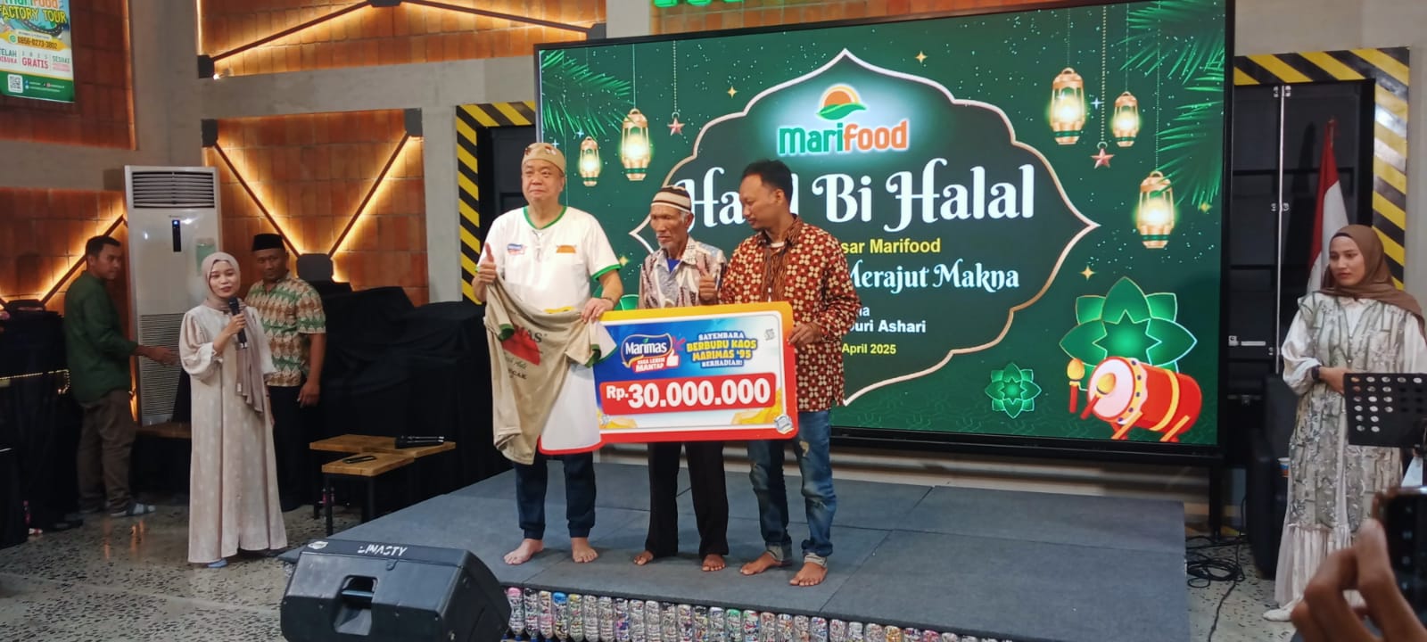 CEO Marifood, Harjanto Halim, menyerahkan hadiah sayembara kaos Marimas produk tahun 1995 kepada Damiri dan anaknya, Khoiri. (sls)