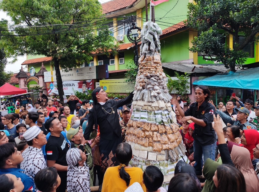 Warga Kelurahan Jomblang saat berebut gunungan dalam tradisi Apitan bertempat di Bundaran Cinde, Sabtu (17/5/2025).