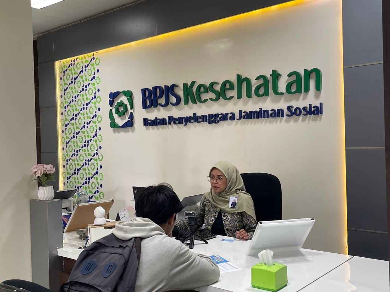 LAYANI DENGAN TULUS : Petugas BPJS Kesehatan melayani peserta JKN di kantor cabang.