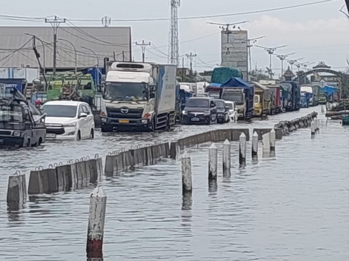 Caption: 1. Kendaraan terjebak macet di jalan raya Pantura Sayung akibat banjir rob tinggi. 2. Kendaraan mengular panjang dilihat dari jembatan batas Demak-Semarang.(Wahibpribadi)  Banjir Rob Tinggi,