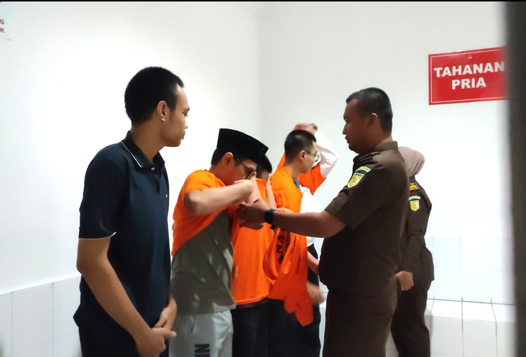 Lima mahasiswa tersangka aksi MayDay saat melepaskan baju tahanan di Kejari Kota Semarang, kini jadi tahanan kota, Kamis (19/6/2025).