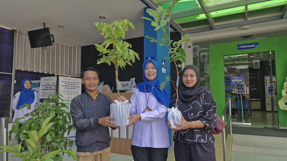 Kepala BPJS Kesehatan Cabang Magelang Maya Susanti menyerahkan bibit tanaman buah-buahan kepada peserta JKN yang mengakses layanan saat ulang tahun ke-57 BPJS Kesehatan, Selasa (15/7/2025).