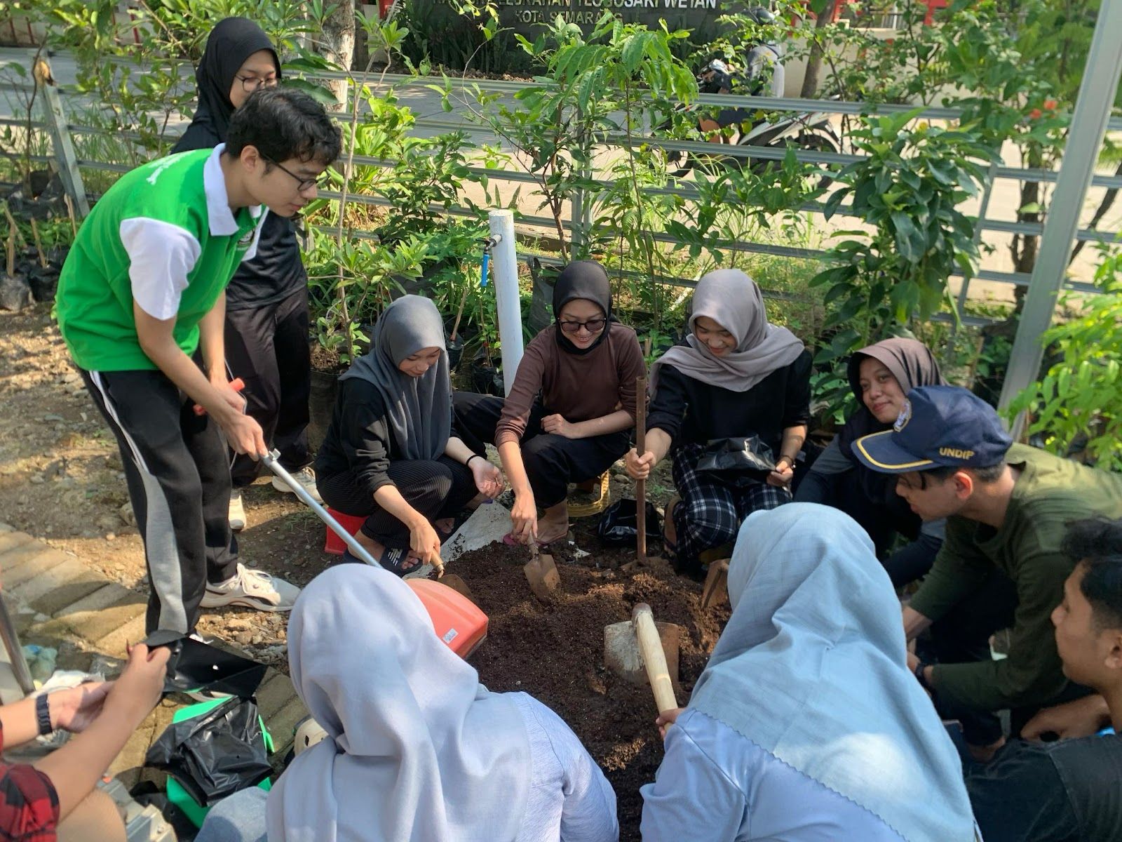 Mahasiswa Kelompok 1 KKN Tim 144 UNDIP 2025 bersama anggota KWT RW 01 Tlogosari Wetan melakukan praktik langsung pengelolaan tanah di area green house sebagai ketahanan pangan