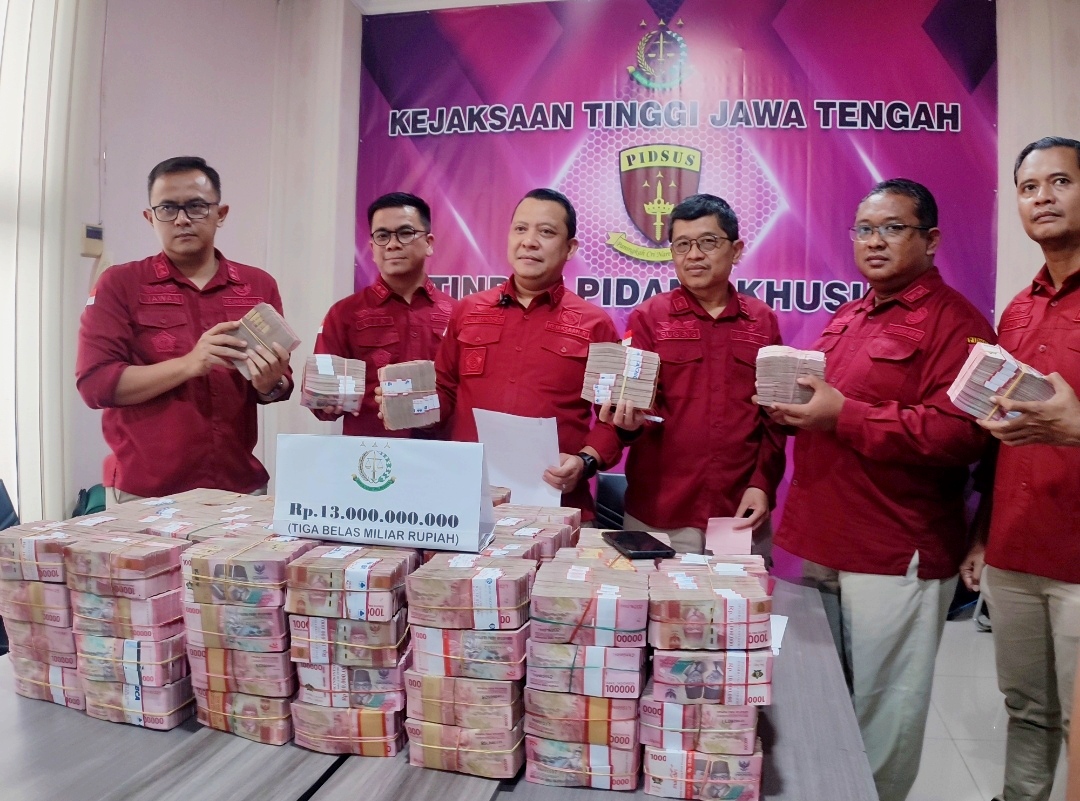 Asisten Tindak Pidana Khusus Kejati Jateng, Alexander Lukas Sinuriya bersama tim penyidik memperlihatkan uang sitaan kasus korupsi Rp 13 miliar, Rabu (16/7/2025).