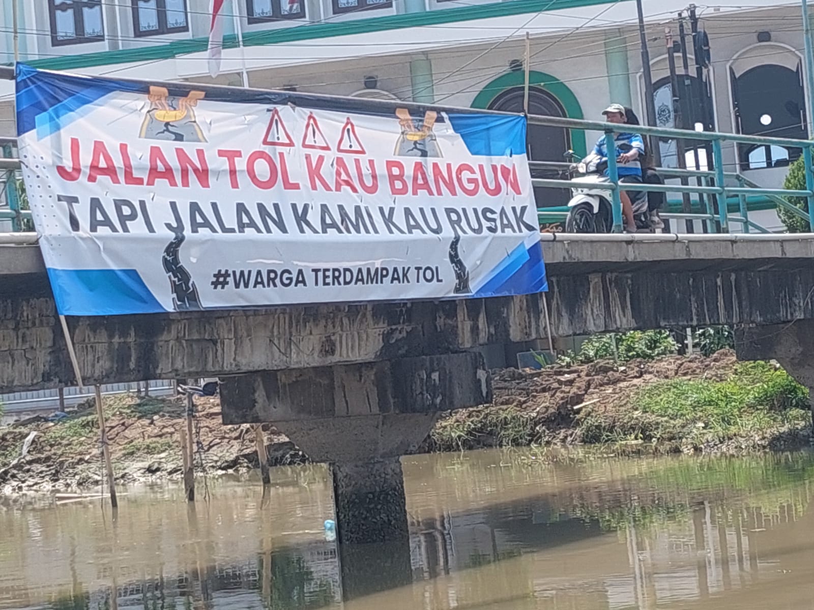 Spanduk protes warga Purwosari Sayung dipasang di jembatan desa.(Wahibpribadi)