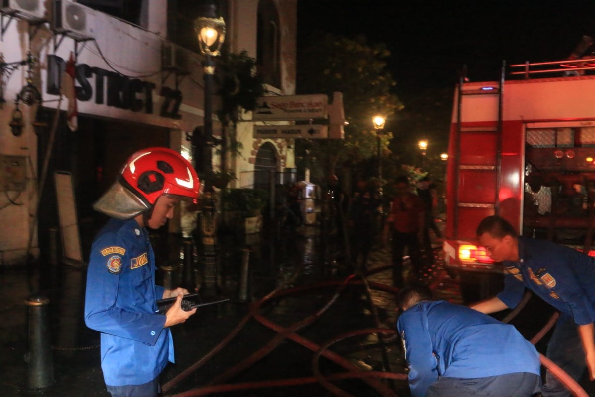 Petugas pemadam kebakaran berusaha memadamkan api yang membakar resto Sego Bancakan di Kota Lama Semarang. (Nurchamim/Jawa Pos Radar Semarang)