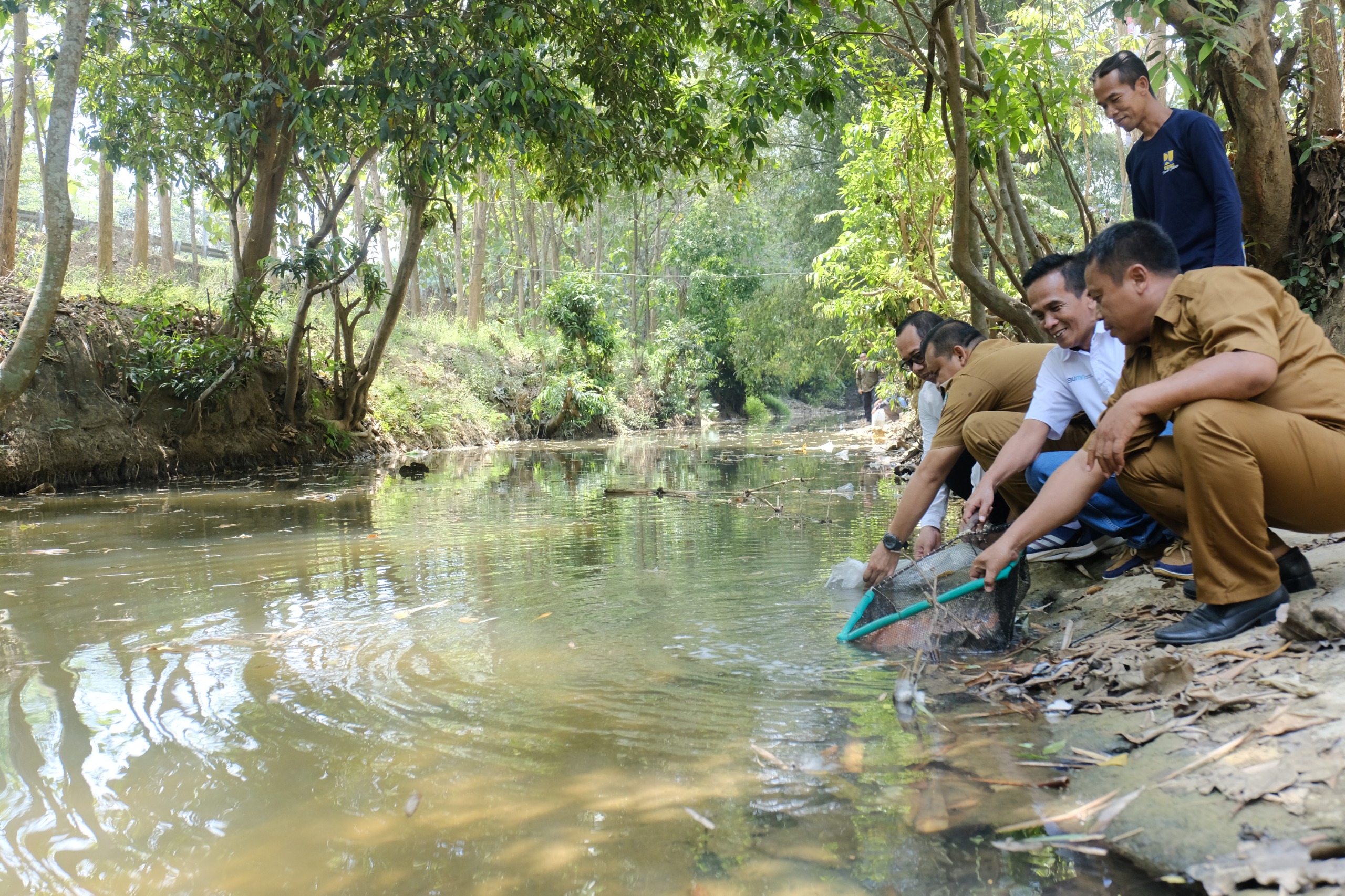 Senior Manager of Communication & CSR PT Semen Gresik, Sulistyono, menyerahkan ribuan bibit ikan air tawar dan melepaskan ikan di aliran sungai Lusi bersama kepala desa Ngampel, Mohamad Astiadi Maryan