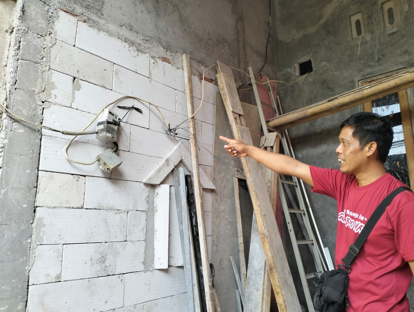 Yono, kerabat pemilik rumah menunjukkan kabel yang akan dipindahkan, Sabtu (13/9) sore.