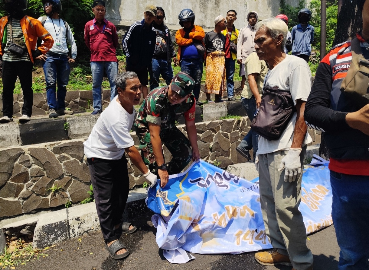 Jenasah telah ditutupi setelah dievakuasi dari selokan