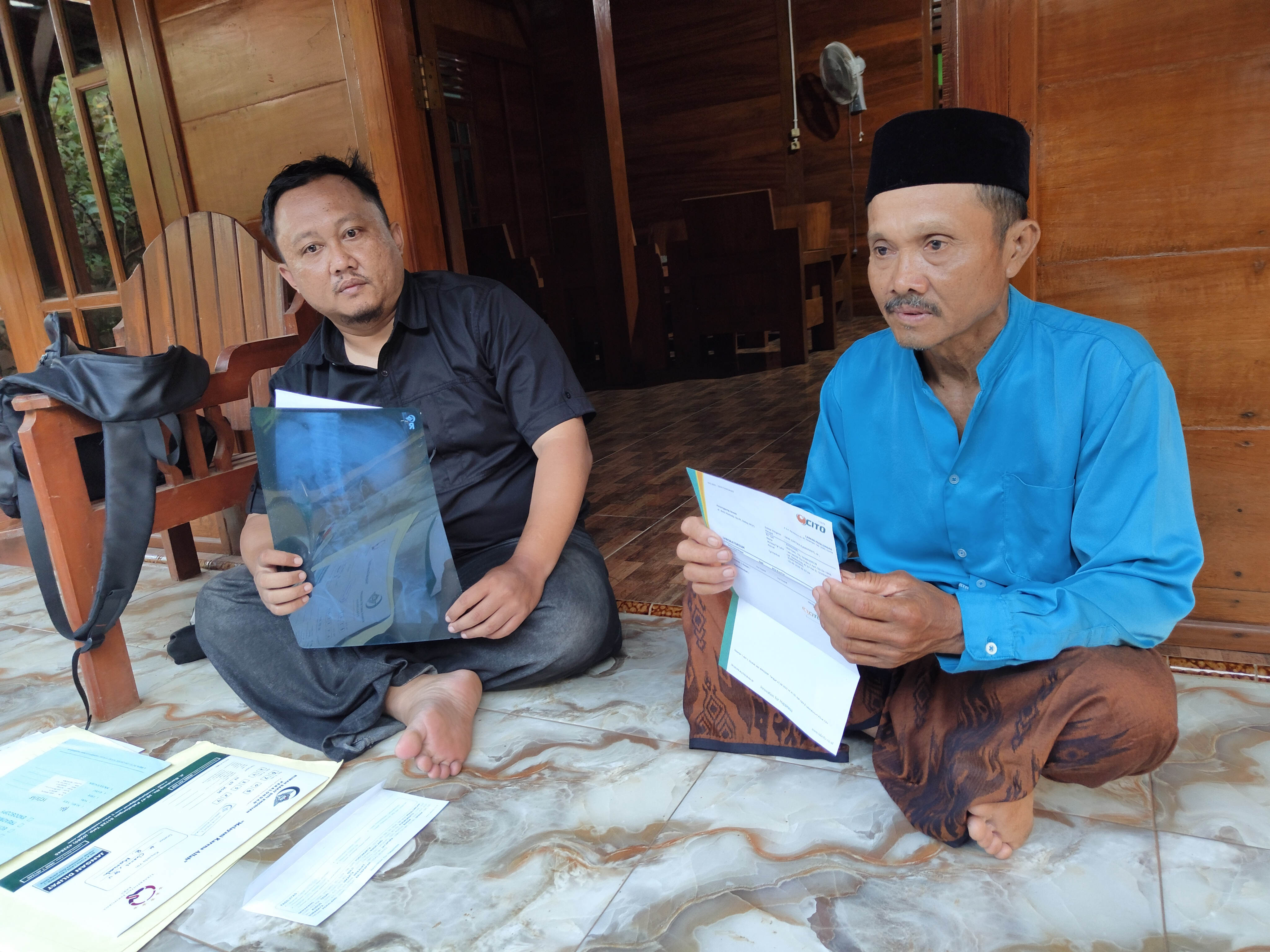 Mistono bersama anaknya menunjukkan hasil laboratorium terkait penyakitnya. RIYAN FADLI JAWA POS RADAR SEMARANG