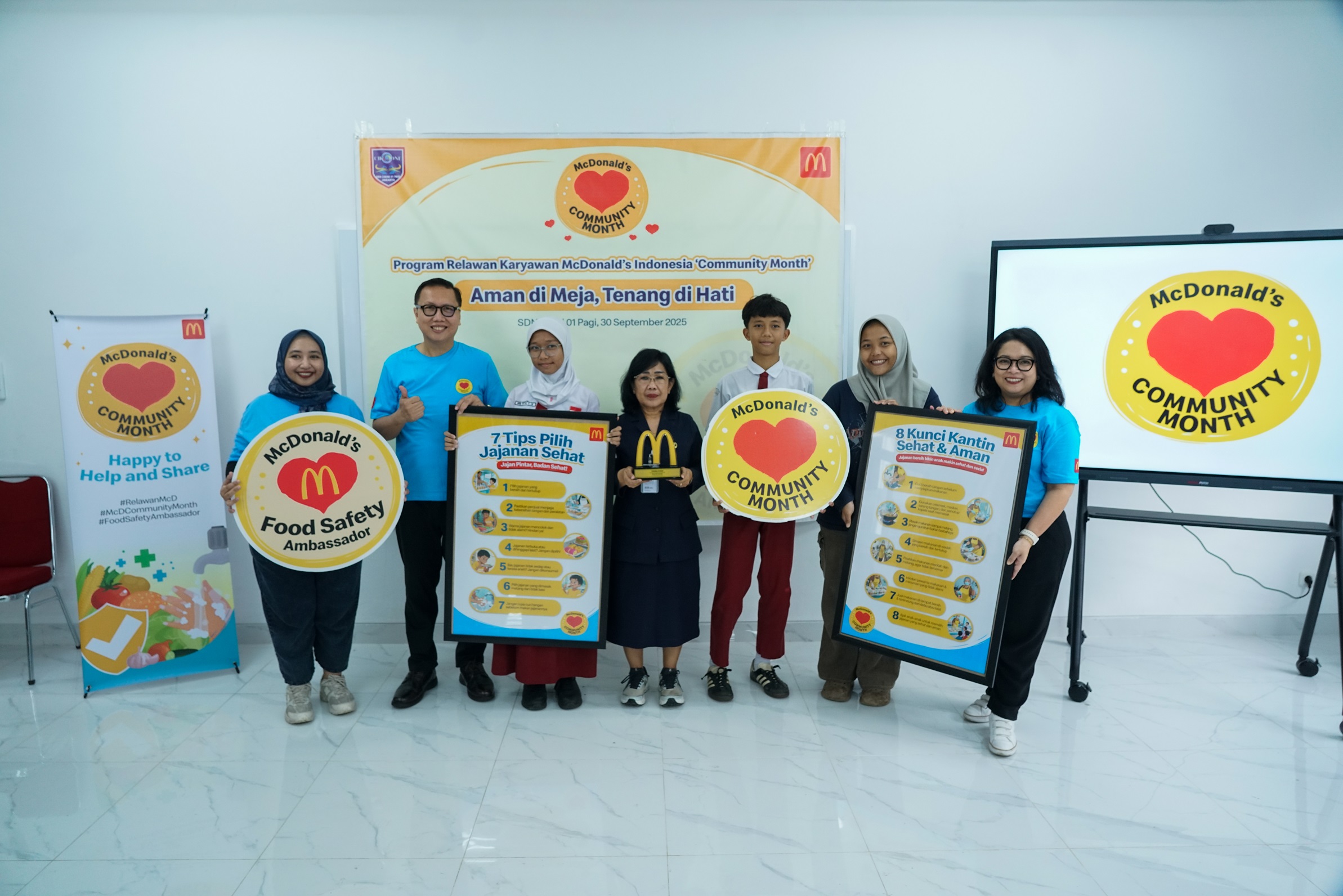 Ronni Rombe, Supply Chain & Quality Assurance Director McDonald&rsquo;s Indonesia, menyerahkan poster tips keamanan pangan dalam kunjungan ke SDN Cikini 01 Jakarta dalam program Community Month 2025.