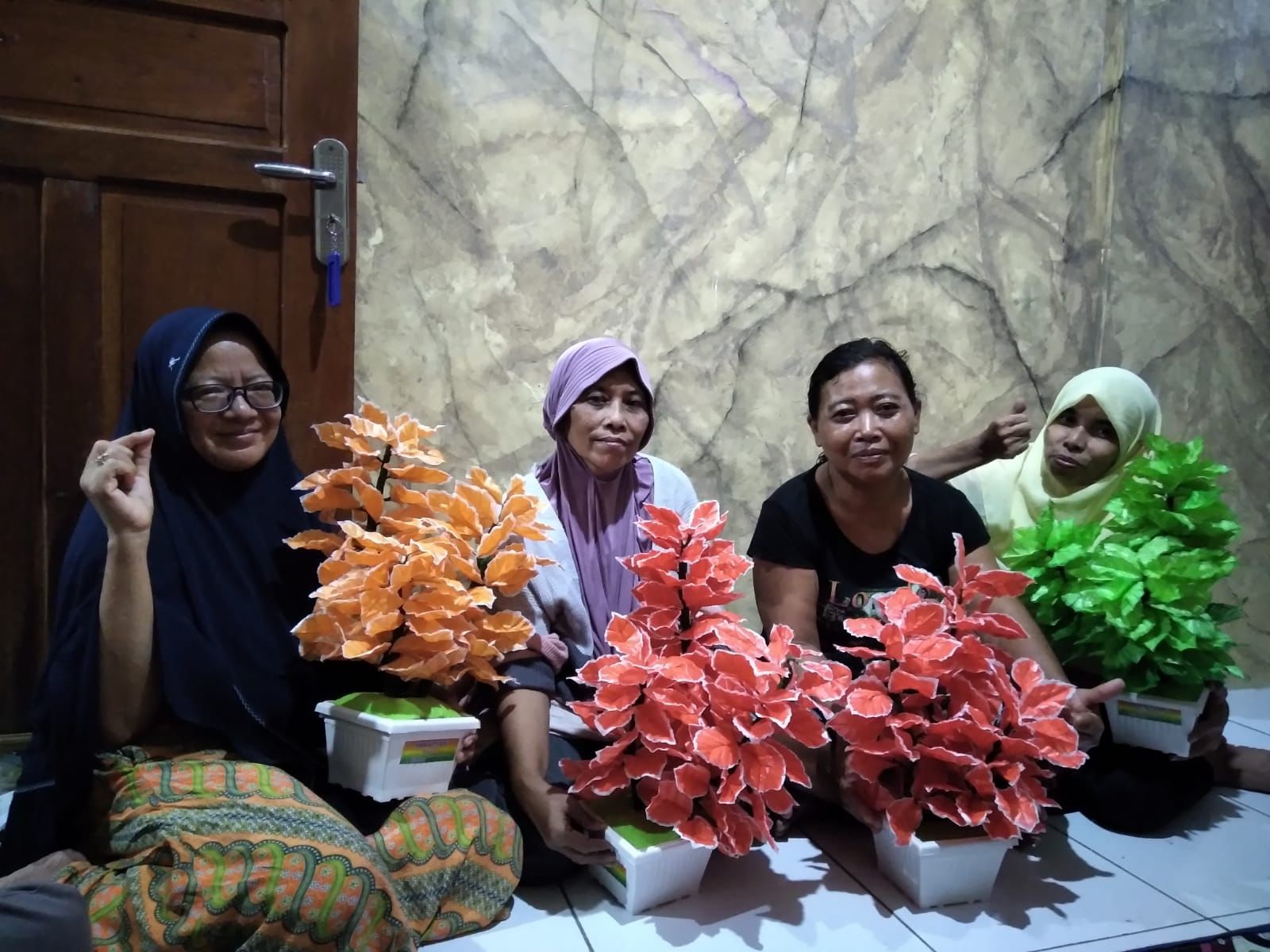 Para ibu RW 04 Kelurahan Petompon menunjukkan bunga yang mereka buat dari tas kresek.
