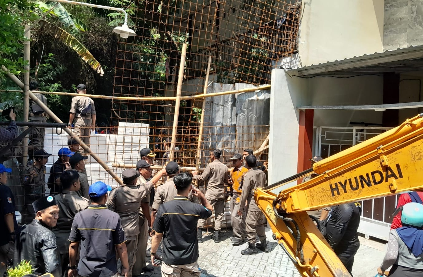 Personil Satpol PP dan alat berat yang diturunkan untuk melakukan pembongkaran pagar penutup akses jalan