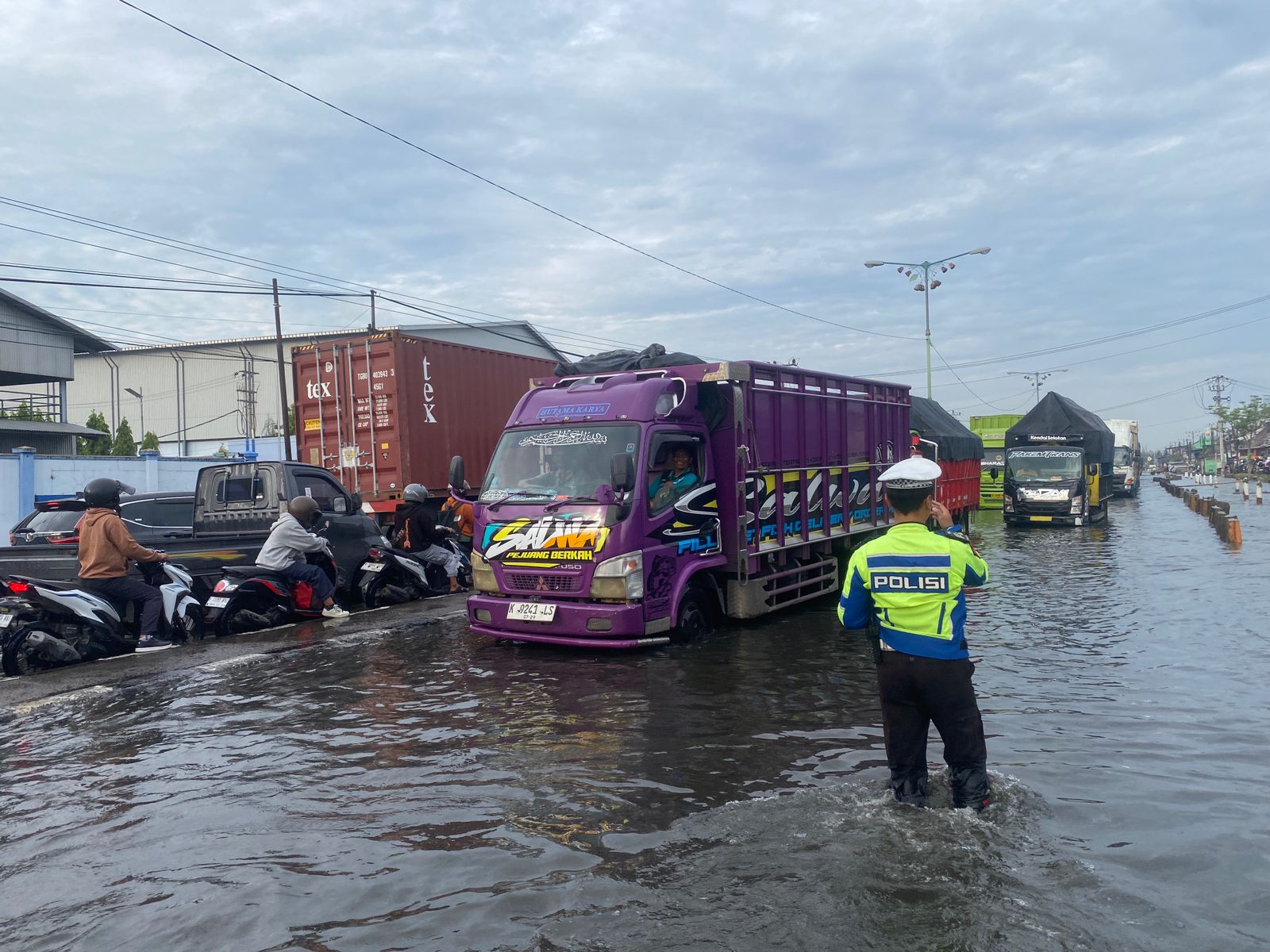 Petugas mengatur lalulintas ditengah banjir dan jalan macet.(wahibpribadi)