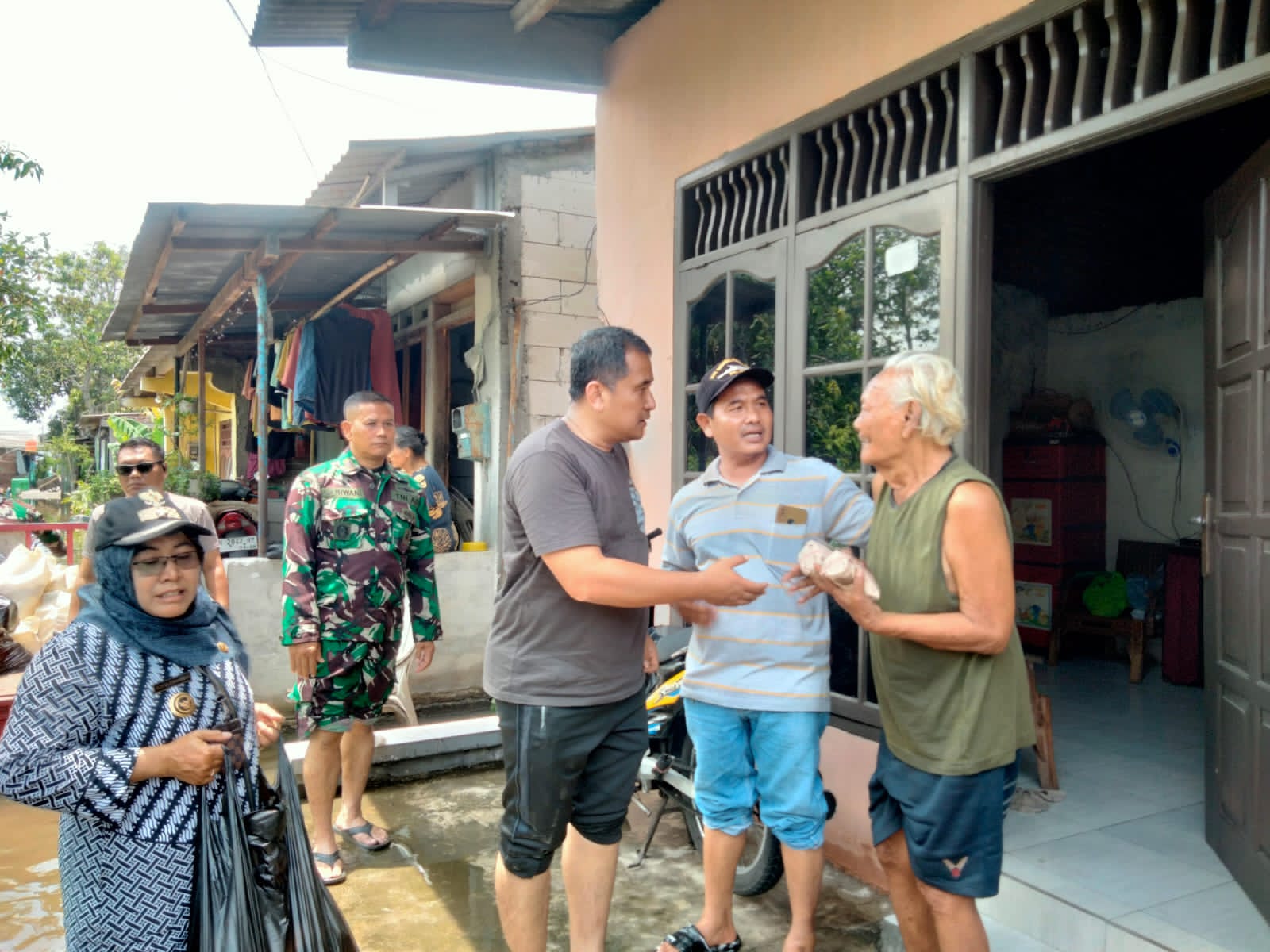 BERI BANTUAN: Camat Pedurungan, Moh Agus Junaidi memberikan bantuan kepada warga terdampak banjir, Kamis (23/10) pagi.