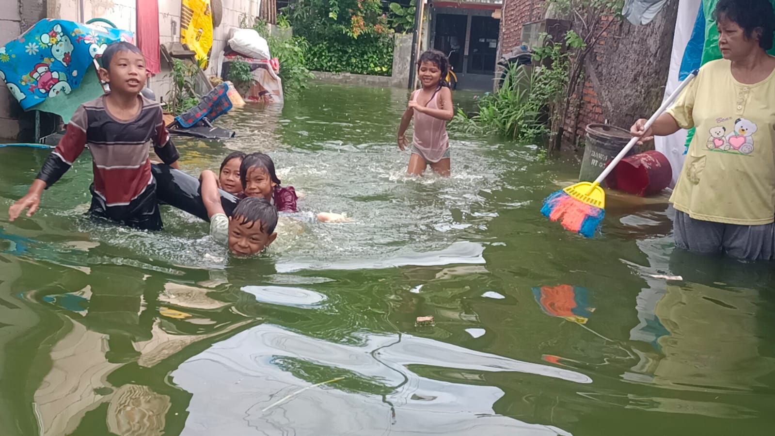 Anak-anak bermain air banjir di wilayah RW 5, Kelurahan Tambakrejo, Kecamatan Gayamsari, Kamis (23/10).