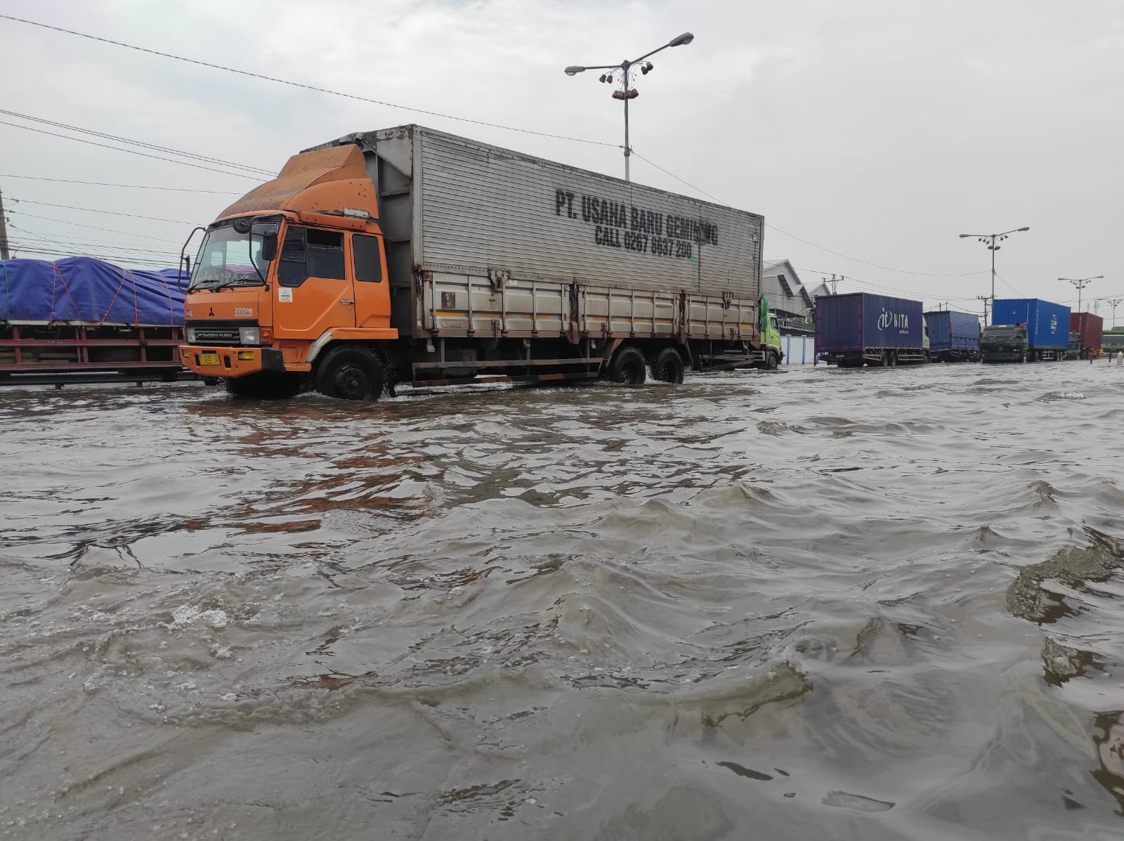 Kendaraan melintas di jalan Pantura Sayung yang terendam banjir kemarin. (Wahibpribadi)    Ketinggian Banjir di Jalan Pantura Sayung Masih 50 Cm, Kendaraan Macet Panjang