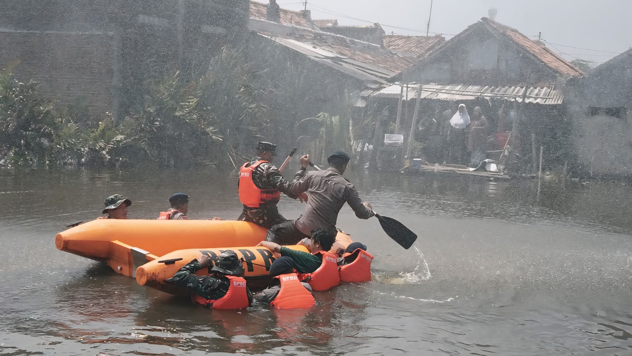 EVAKUASI &ndash; Tim gabungan saat melakukan simulasi evakuasi korban banjir, di tengah guyuran hujan lebat dan banjir yang dalam di perkampungan.