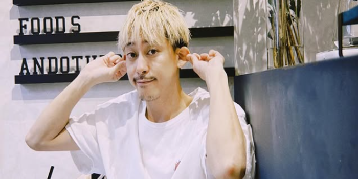 Tangkapan layar dari Instagram gaku_sano_09, yang sedang duduk di sebuah kafe sambil berpose lucu dengan menarik kedua telinganya. Ia tampak mengenakan kaus putih dan duduk di depan meja.