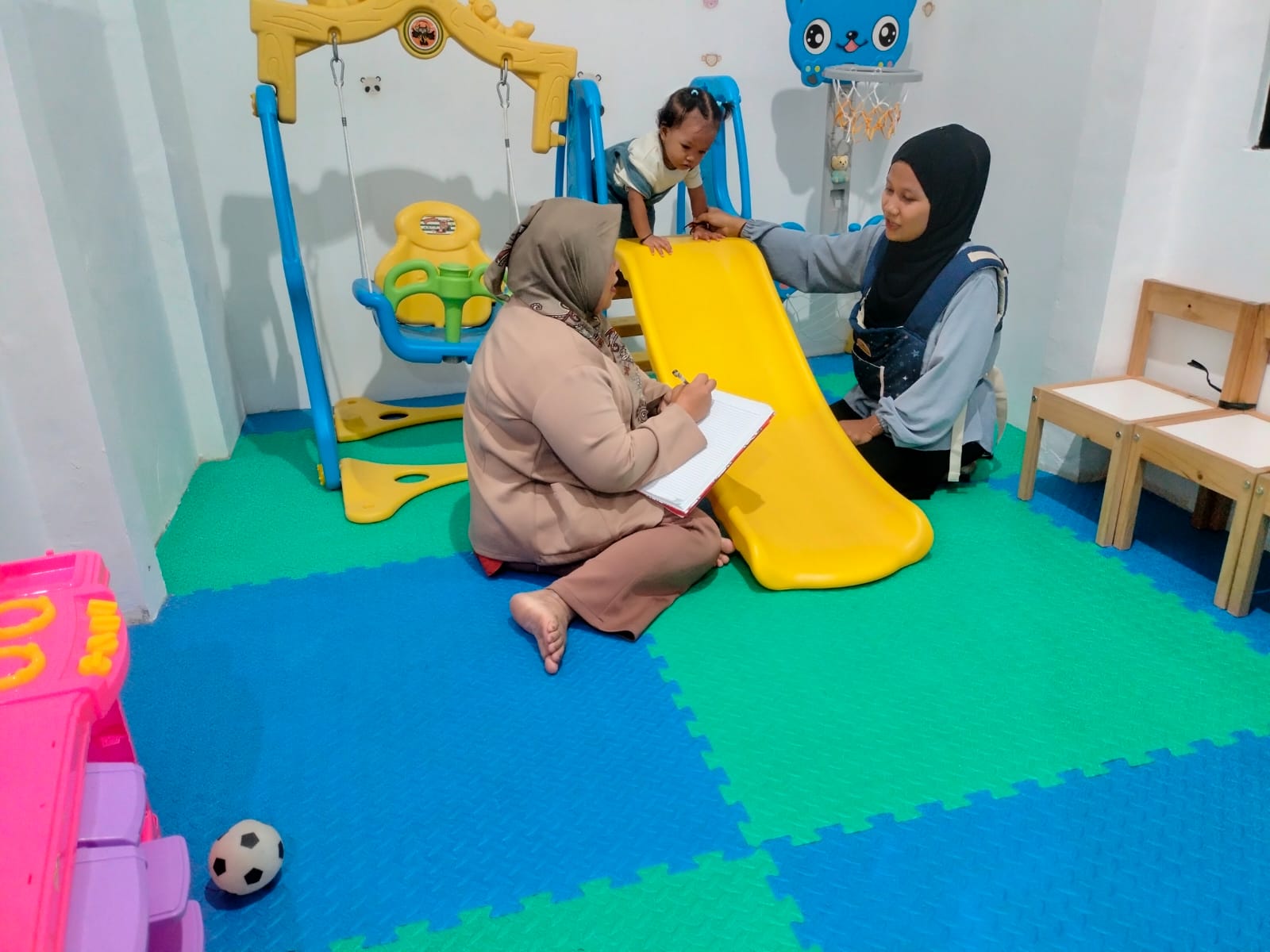 Koordinator Rumah Anak SIGAP Bandaraharjo, Itis Arliani sedang melakukan pendataan pada peserta Rumah Anak SIGAP yang baru.