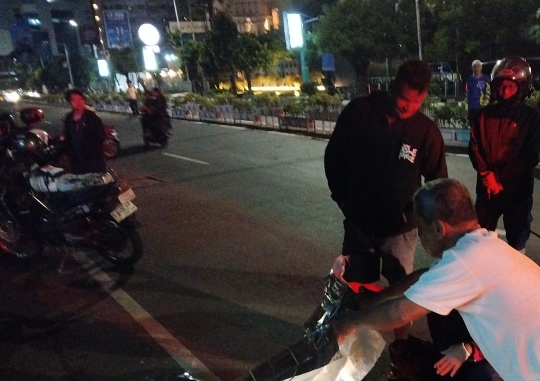 Warga menutupi jenasah pemasang MMT yang meninggal usai tersengat listrik dan jatuh