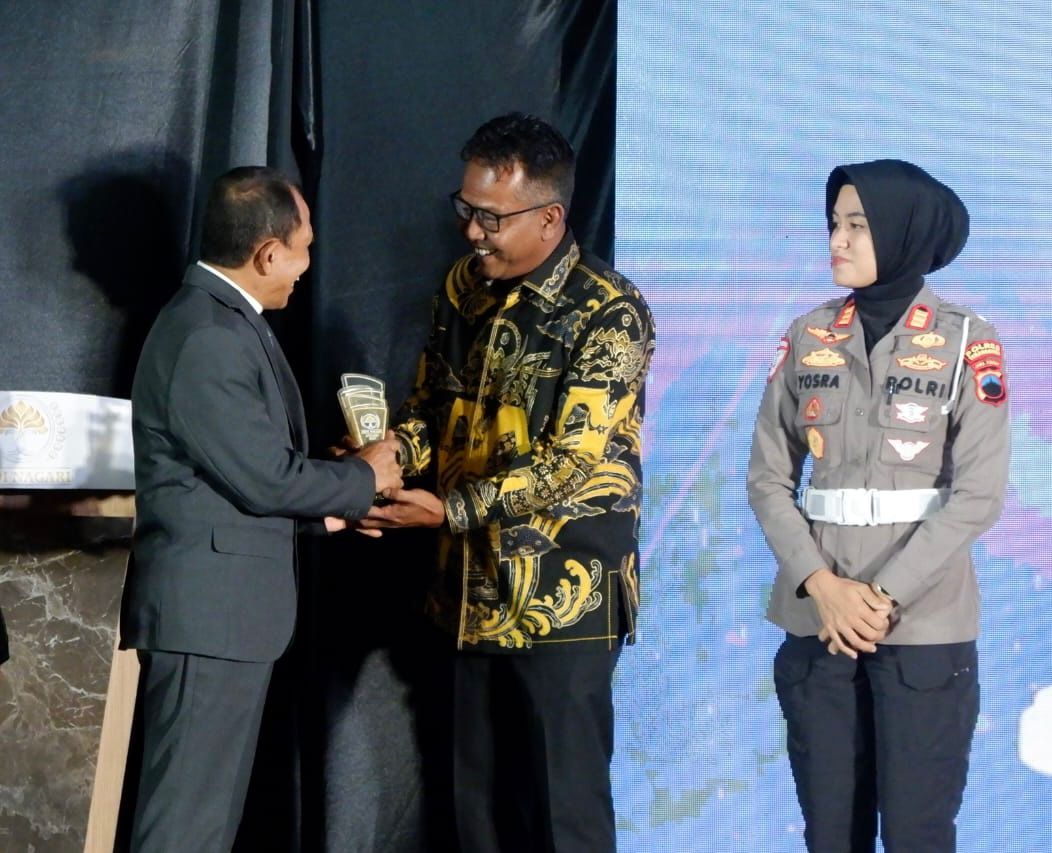 Direktur Jawa Pos Radar Semarang, Baehaqi saat menyerahkan penghargaan pada Kepala Kejari Kota Semarang, Andhie Fajar Arianto di Hotel Normans Semarang, Jumat (12/12/2025
