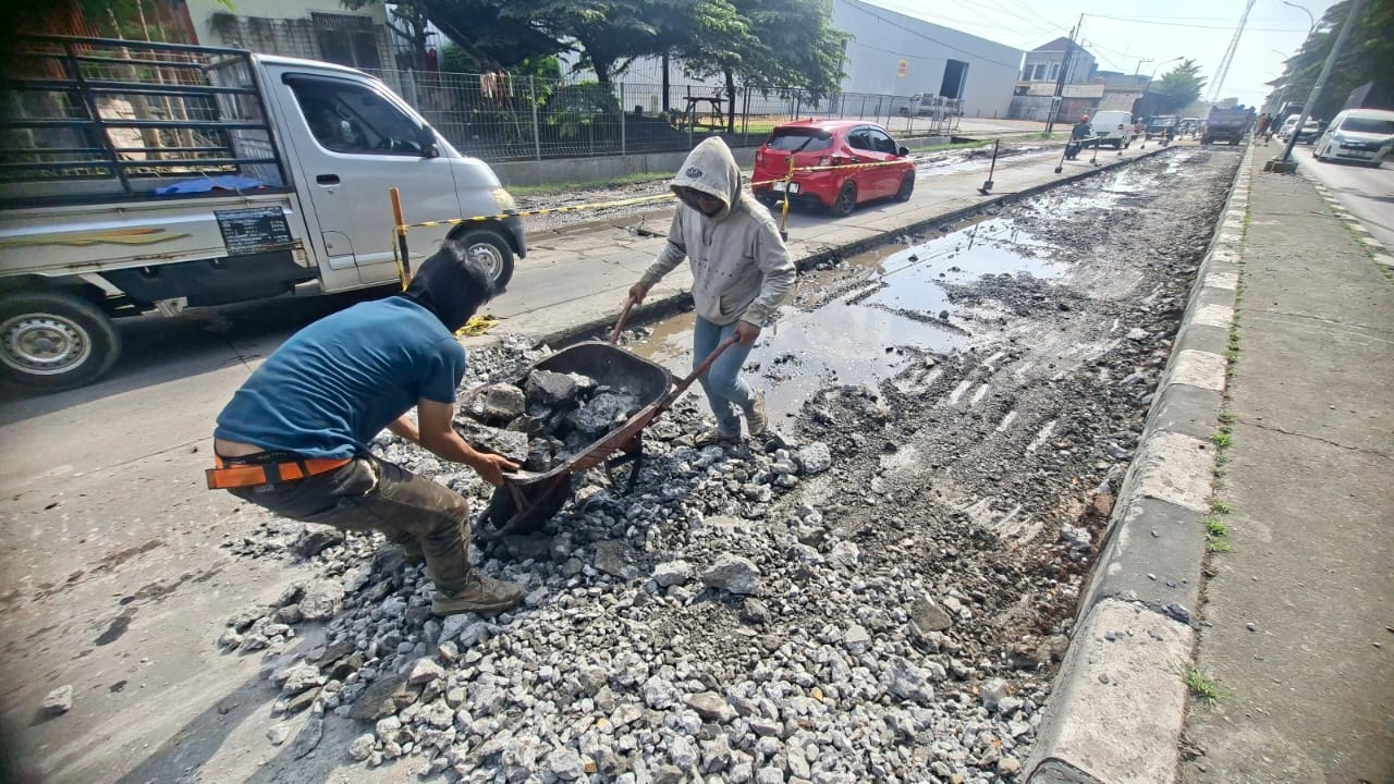 Caption: Pekerja menyingkirkan bongkaran beton di jalan raya Pantura Trengguli Demak.(Wahibpribadi)