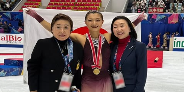 Tangkapan layar dari akun Instagram resmi sysmex_figureskatingteam, menampilkan Kaori Sakamoto yang tersenyum bangga sambil mengenakan medali emas dan membentangkan bendera Jepang.